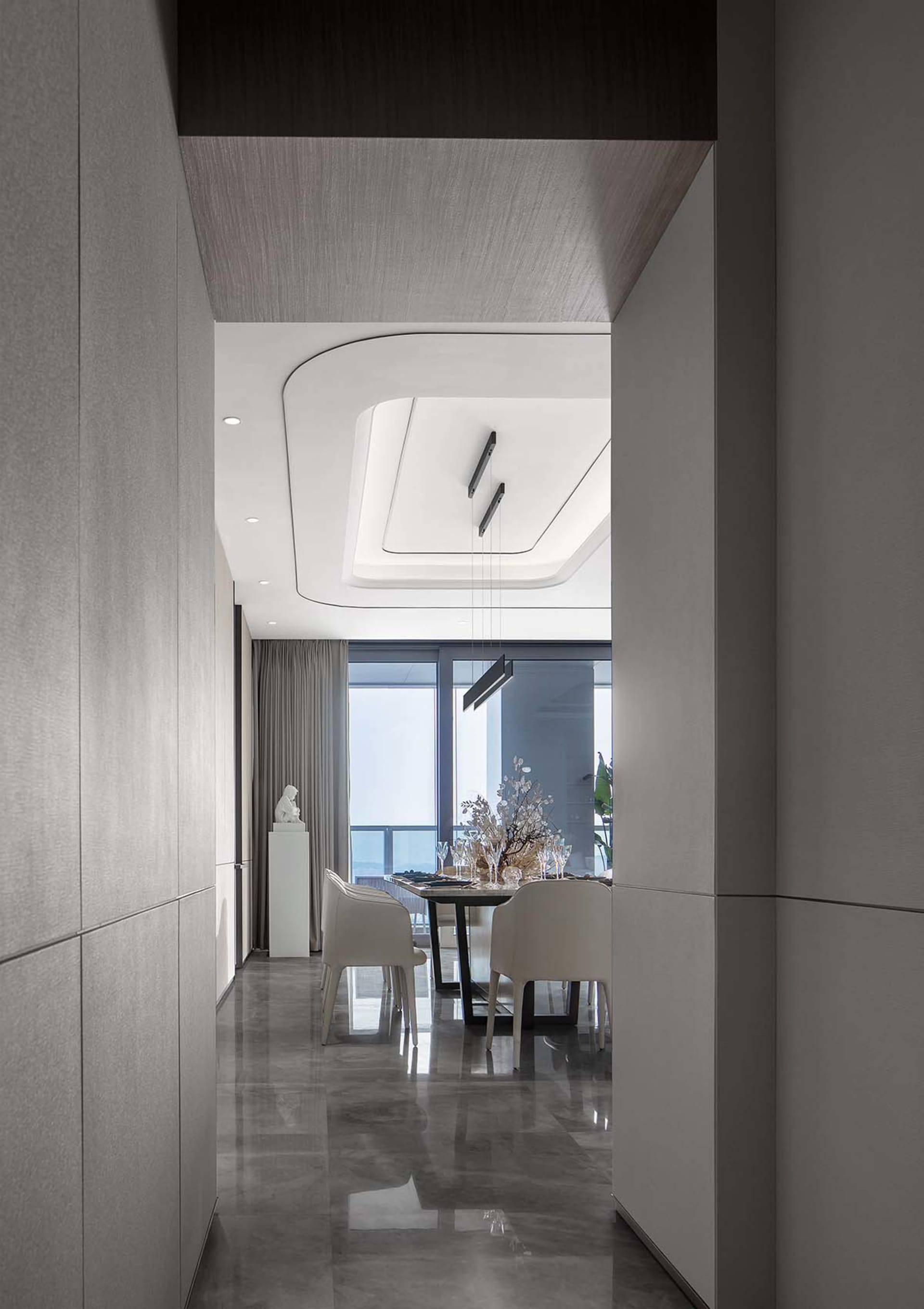 Modern dining room featuring a sleek tile wall and contemporary light fixtures.