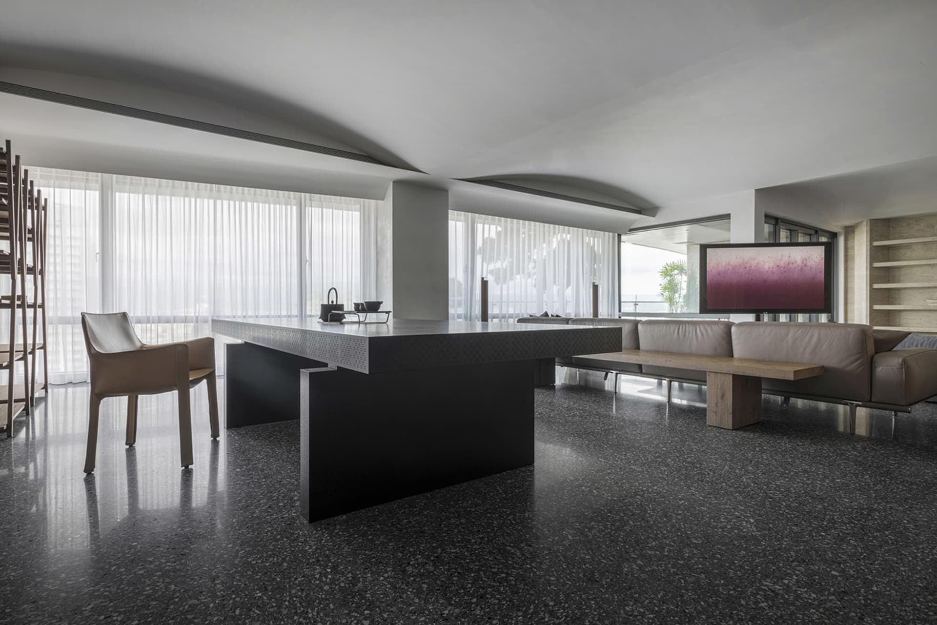 A modern living room featuring minimalist design with concrete and marble elements.