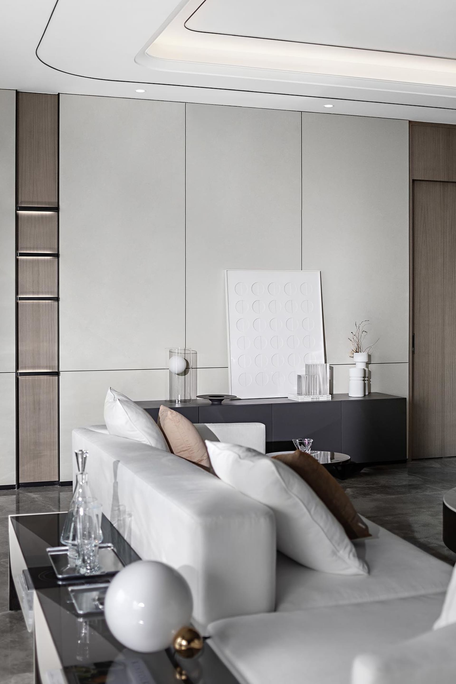 Contemporary living room featuring a modern minimalist design with a white leather couch, accentuated with soft pink pillows