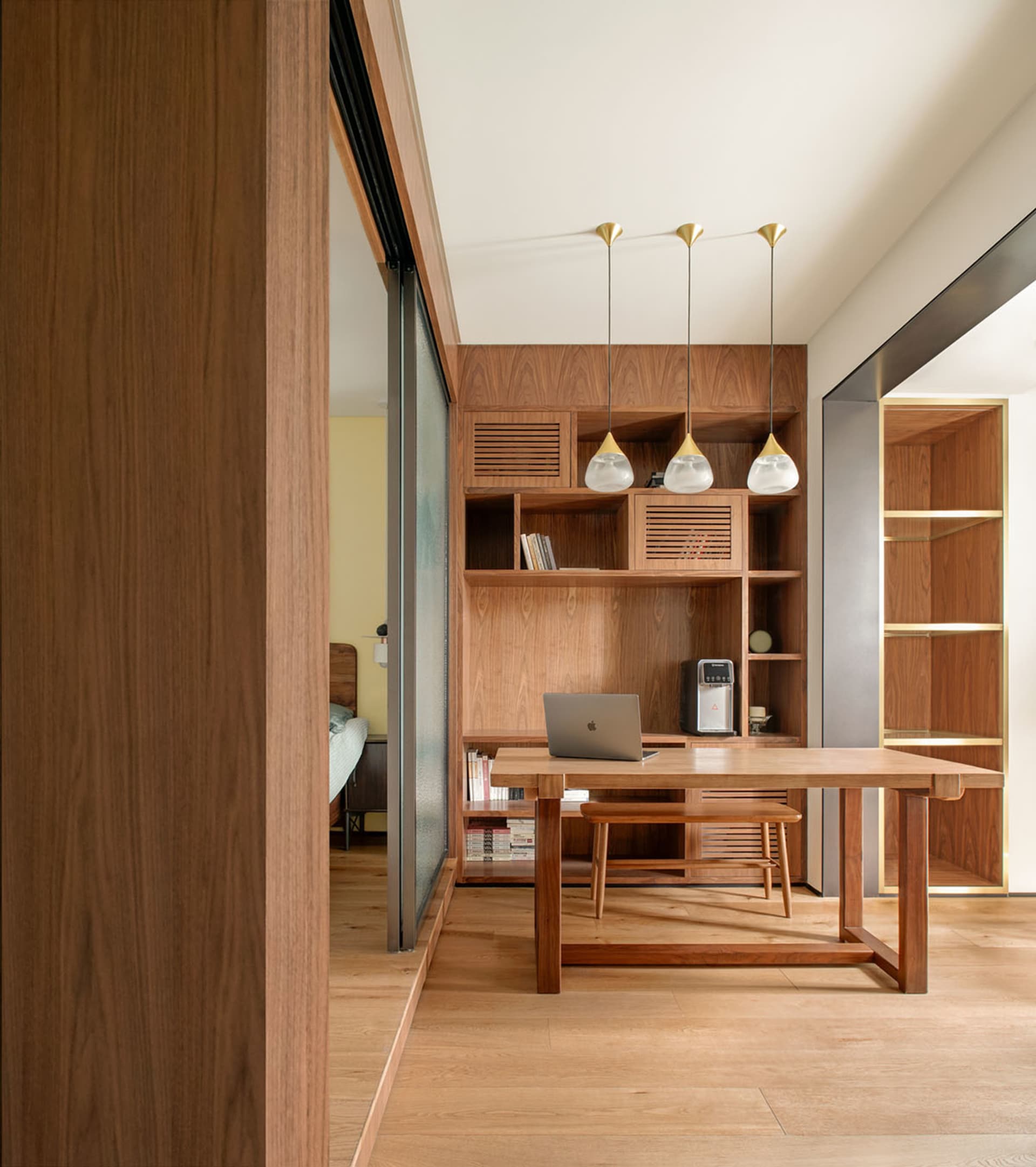 A minimalist home office featuring a wooden desk and shelves.