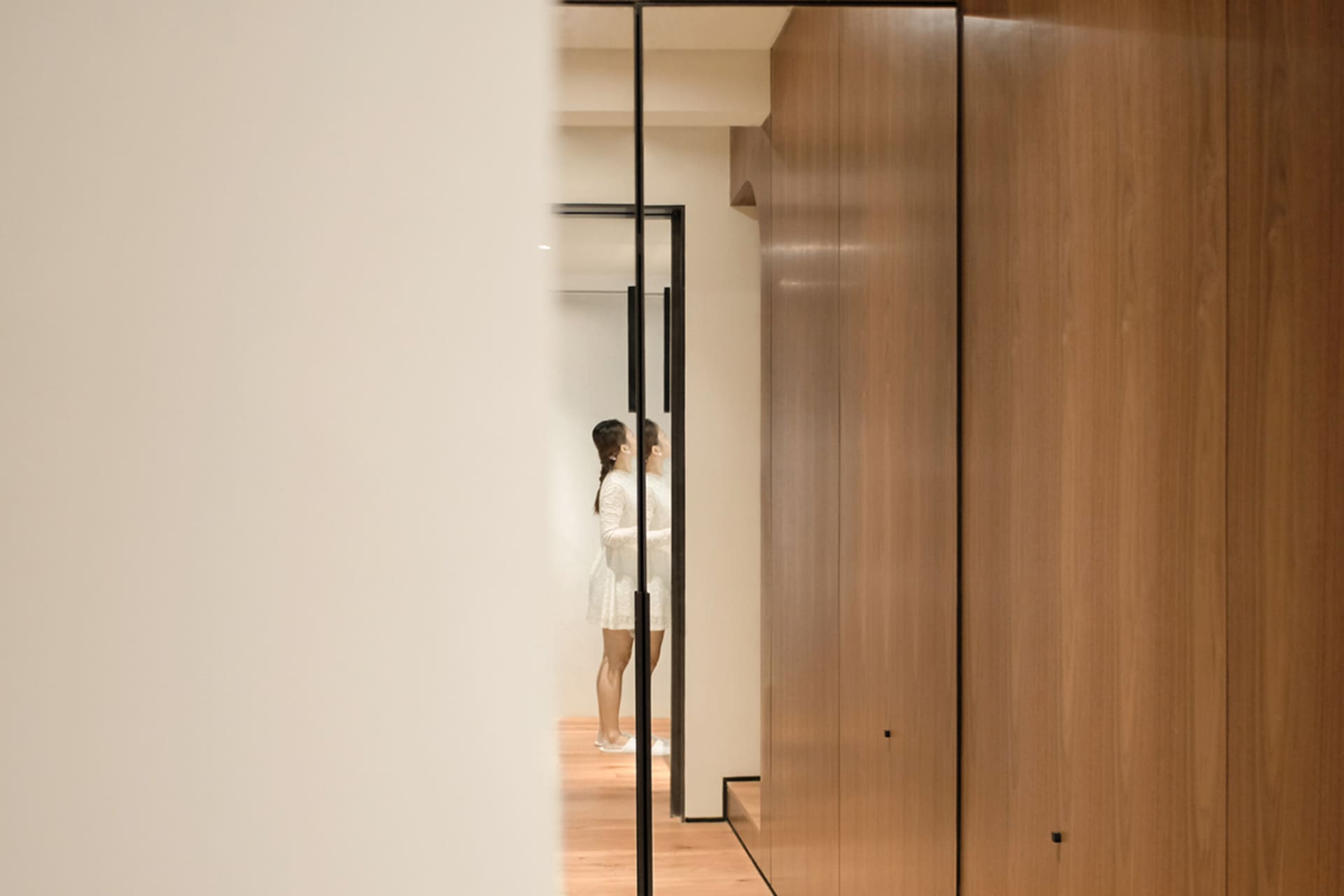 A modern living room with wooden walls and glass doors.
