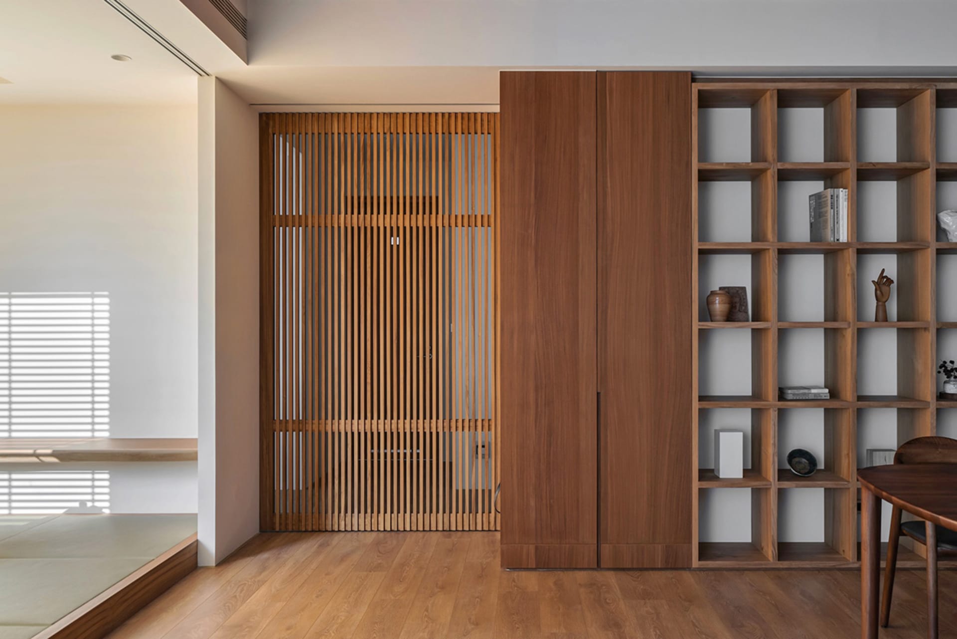 A minimalist interior design featuring a wooden library with wooden slatted walls.