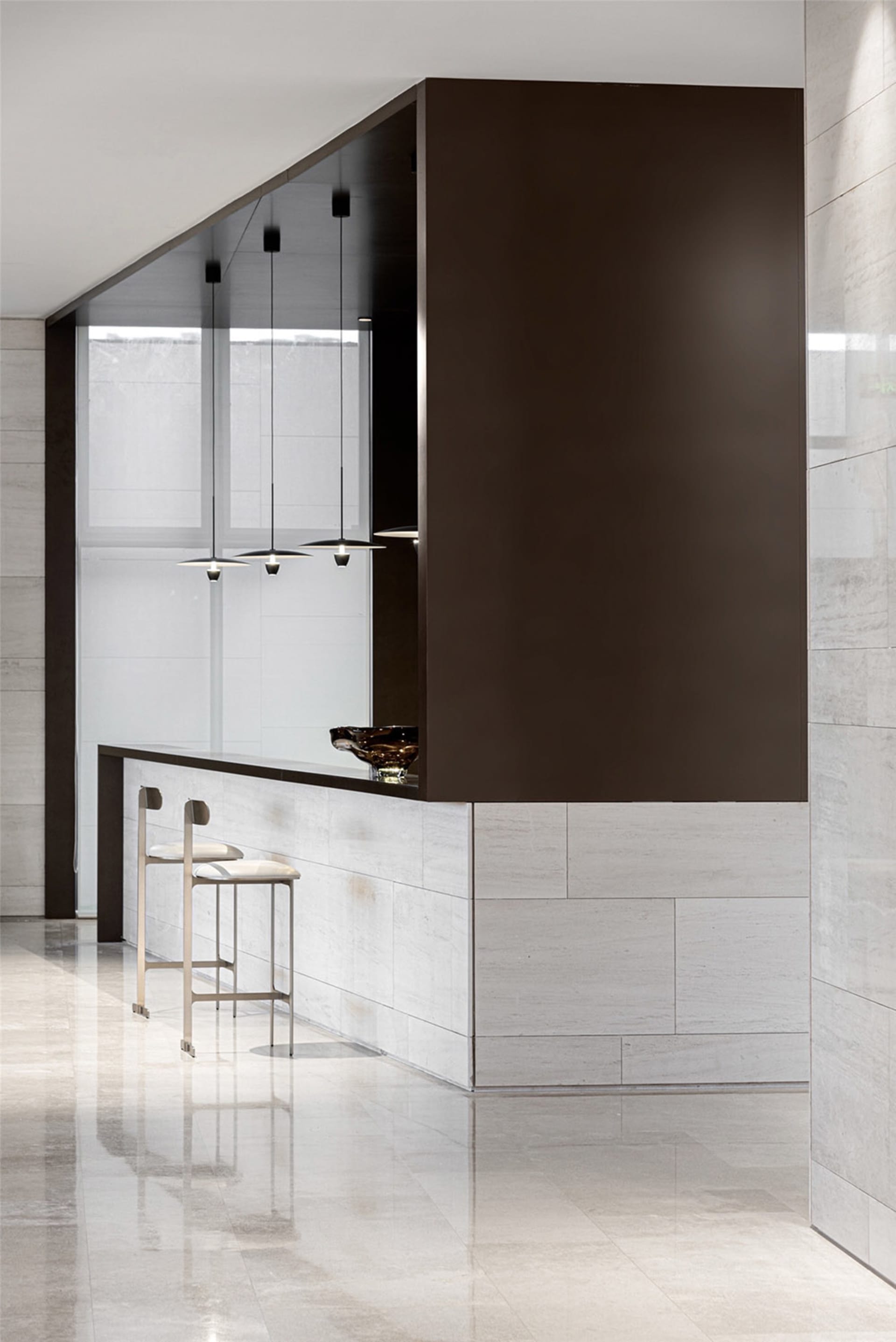 A modern coffee bar with a concrete and marble design, featuring minimalist lighting and sleek seating.