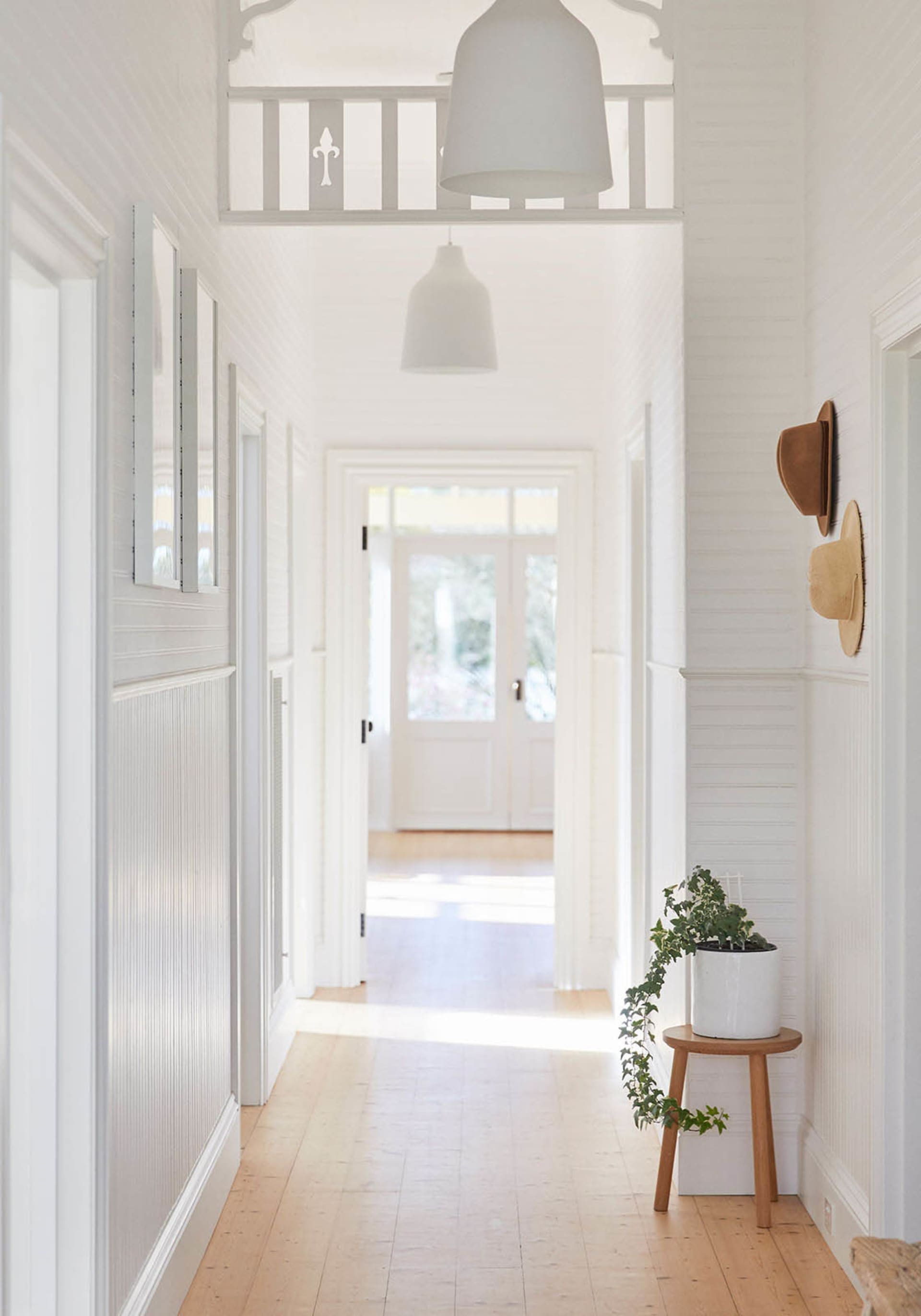 A minimalist corridor with white walls and a wooden floor