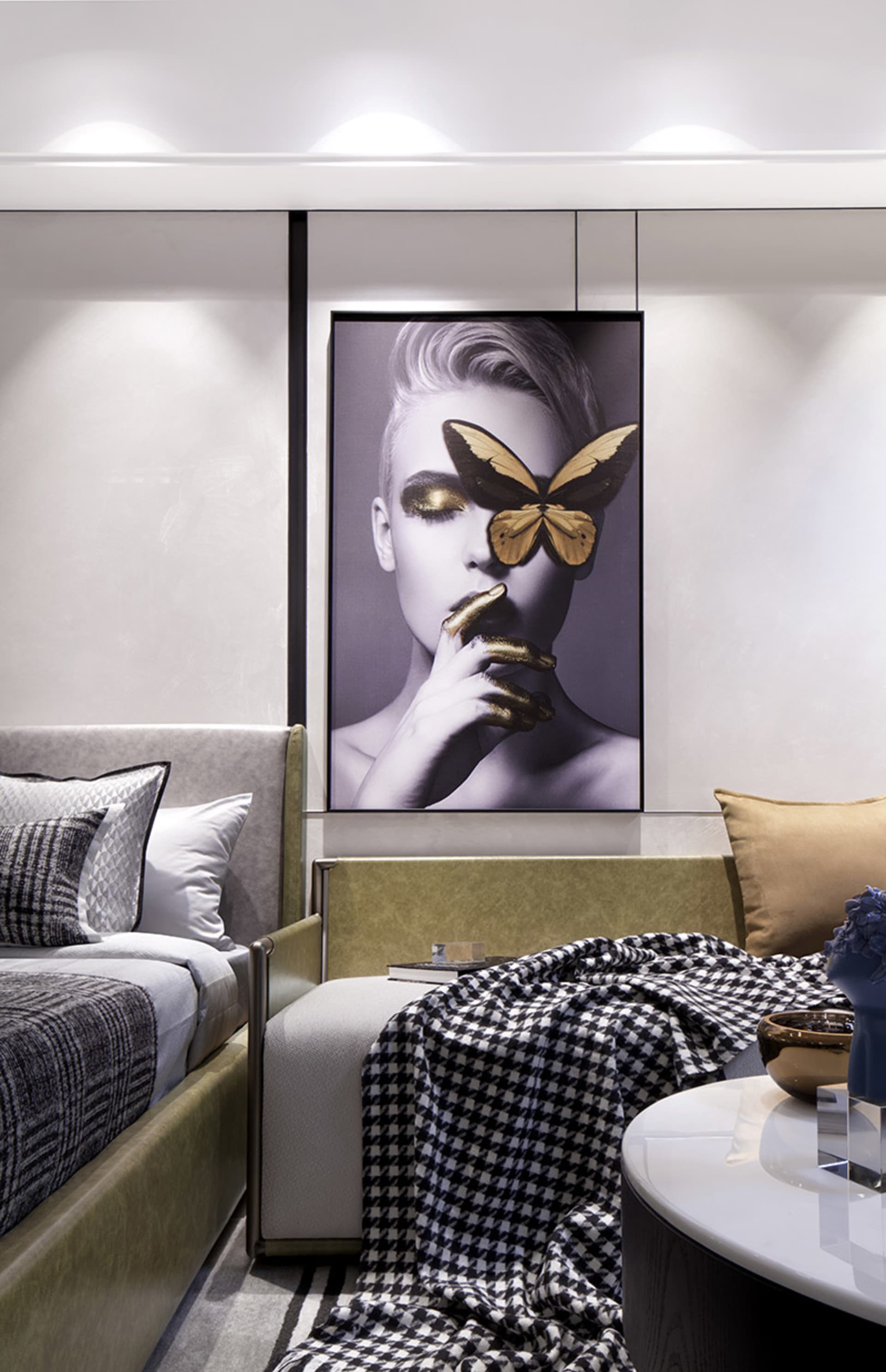 Modern minimalist bedroom with soft lighting, textured fabric bedding, and a striking artwork featuring a woman and a butterf
