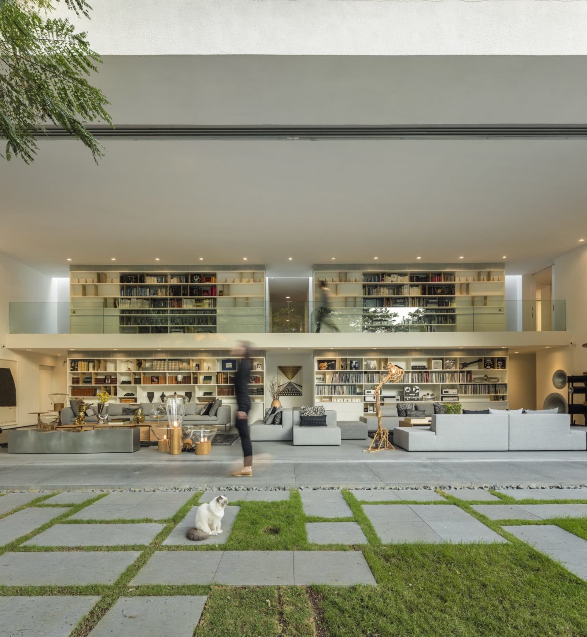 Modern living room featuring concrete flooring and large bookshelves.