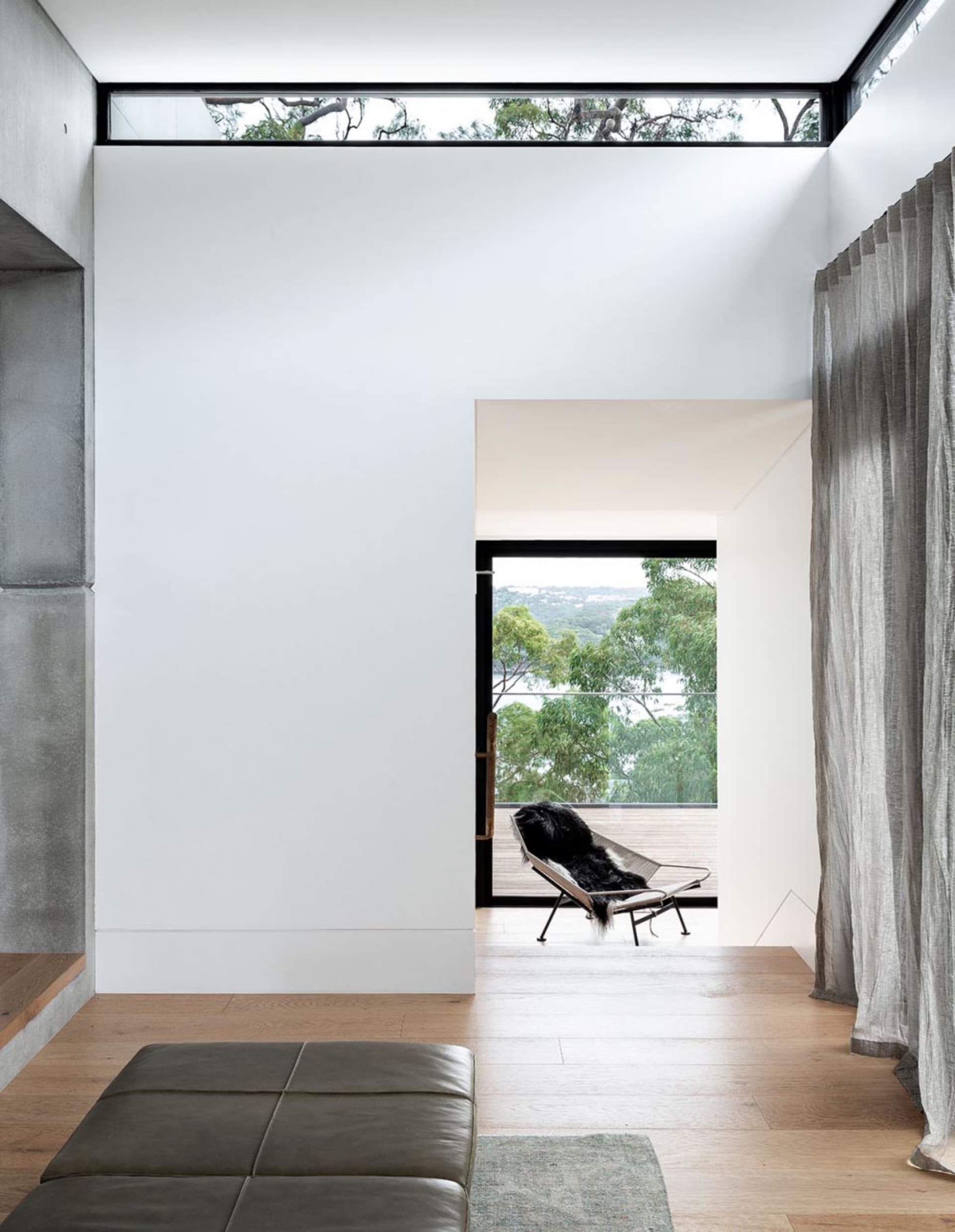 Modern living room with wooden floors, concrete walls, and textiles.