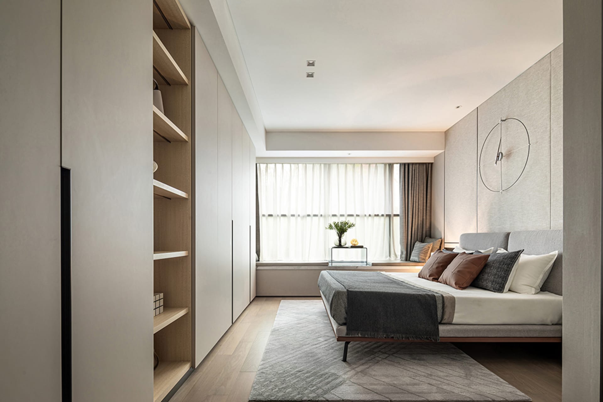 A modern minimalist bedroom featuring neutral tones and a tidy, organized space.