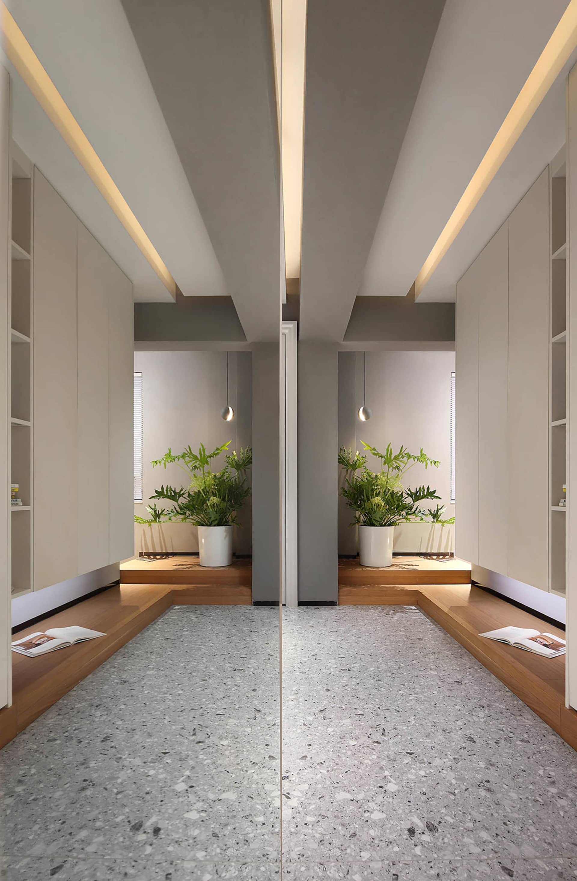 Modern living room featuring gray terrazzo tiles, white built-in shelves, and potted plants with green leafy plants.
