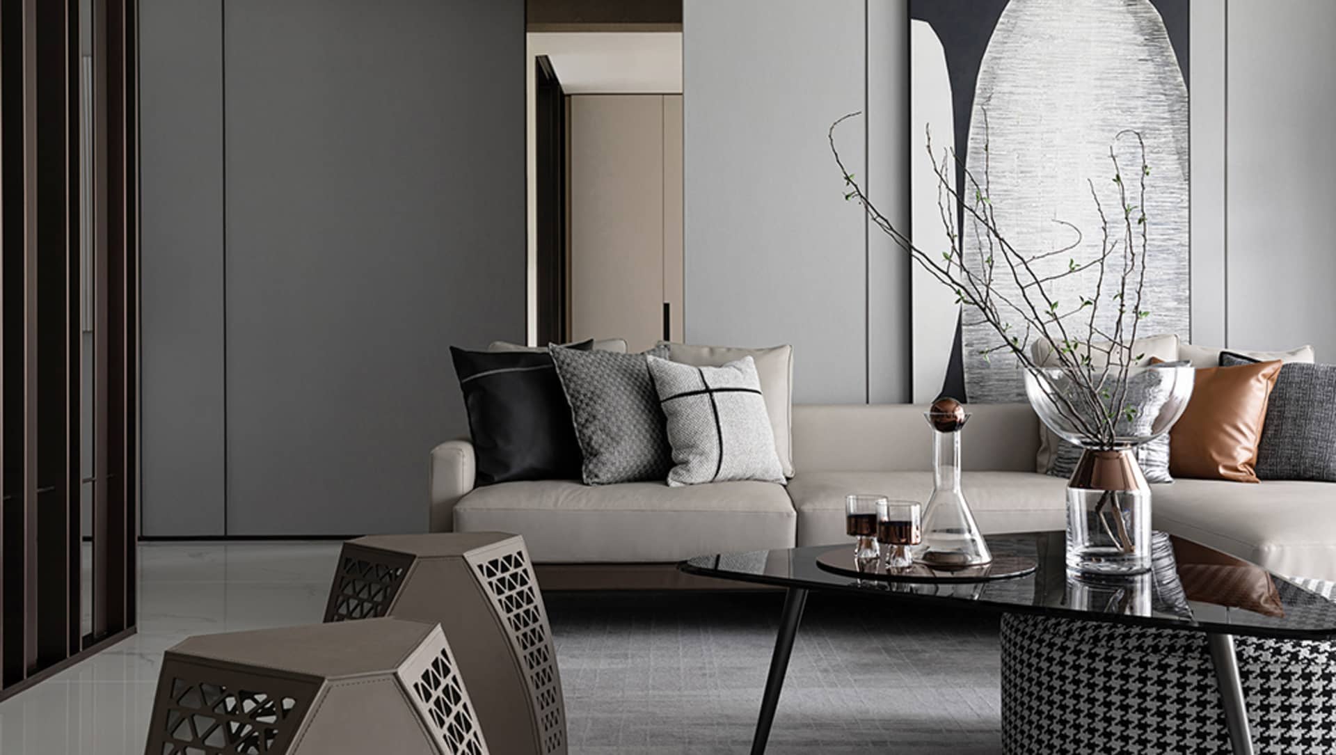 Modern living room with mixed materials, including a white sofa with patterned cushions, a glass coffee table, and geometrica