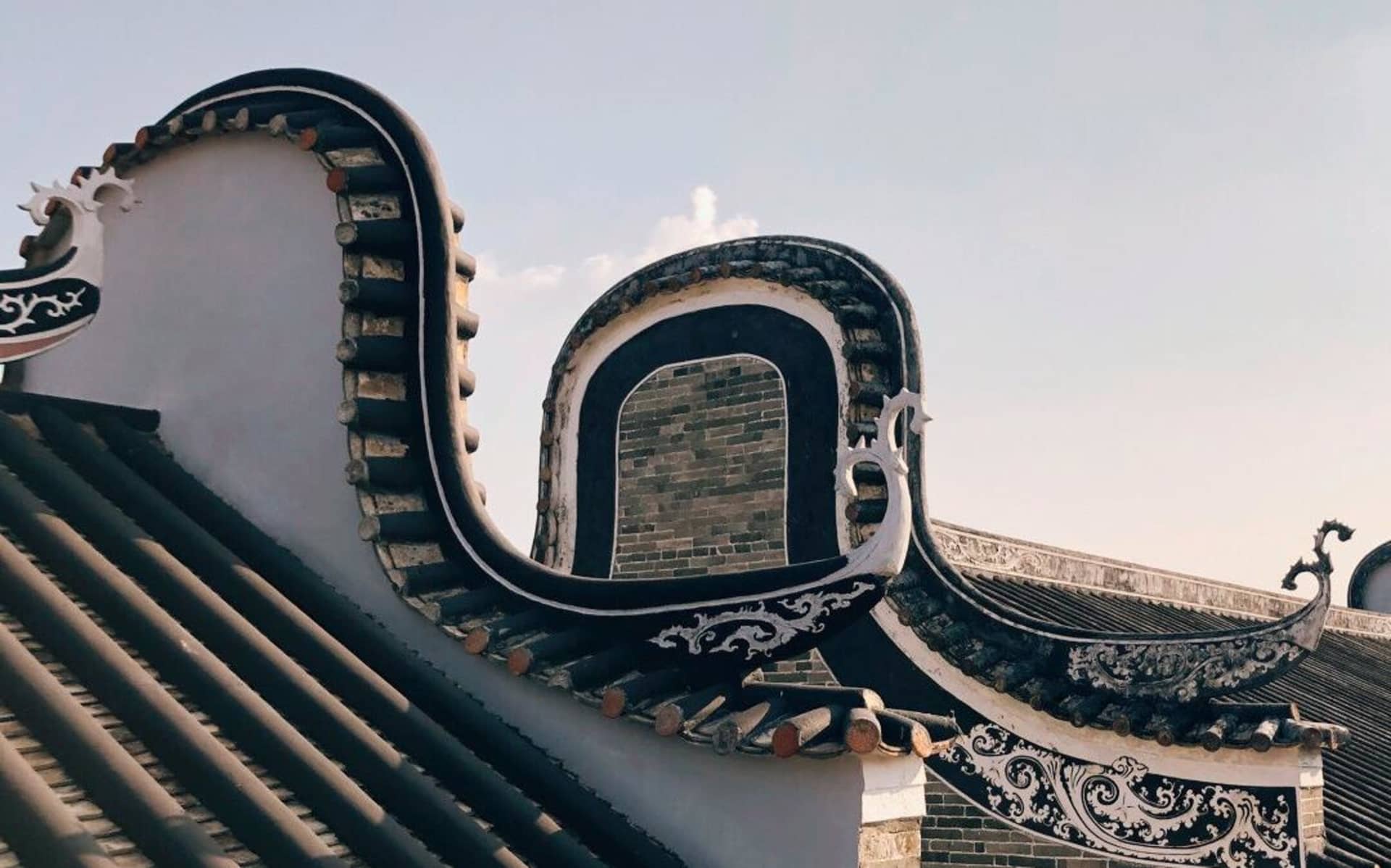 Traditional roof design of an aristocratic building with dark tiles and ornate metalwork.
