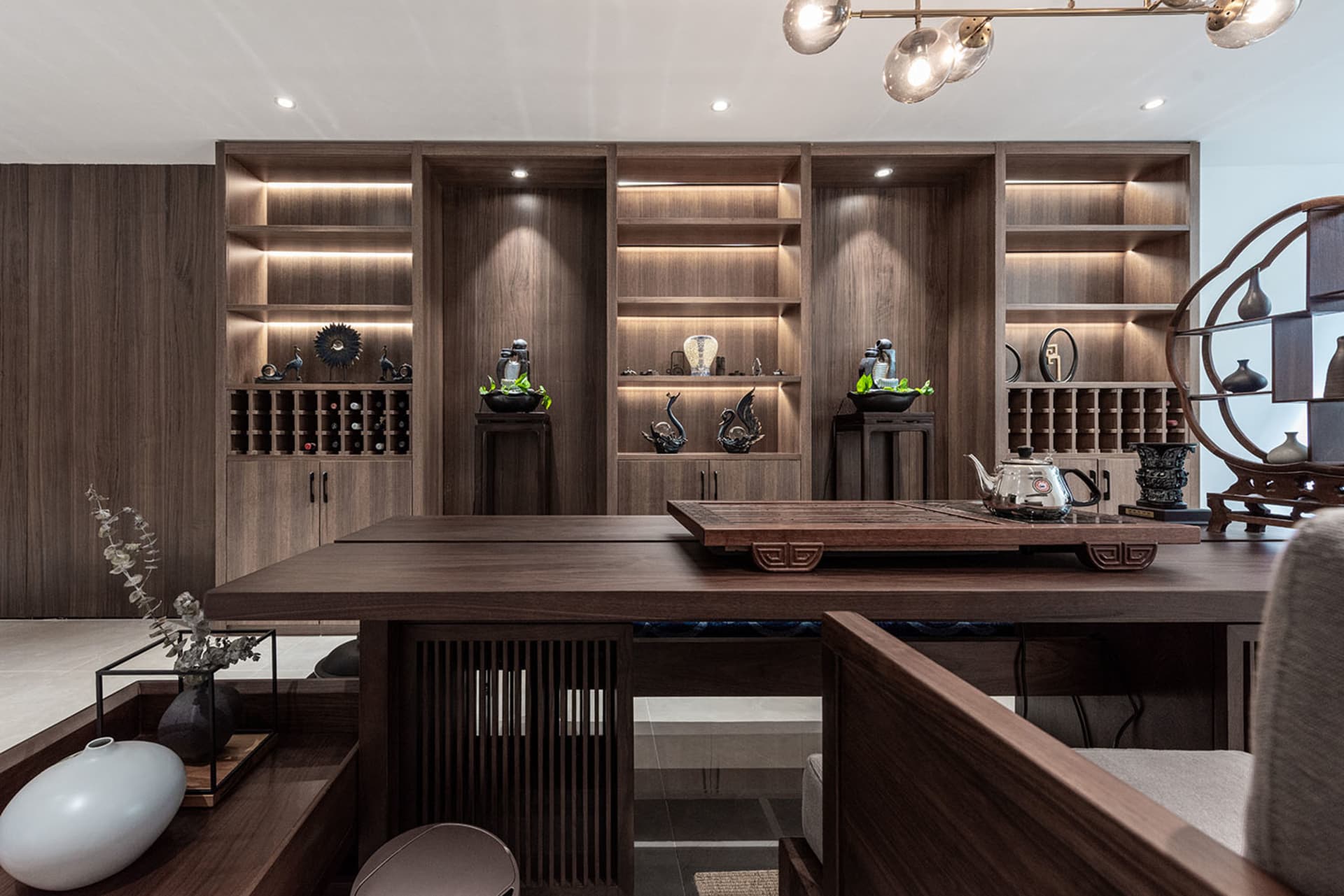 A modern tea room with wooden furniture, shelves, and decorative items.
