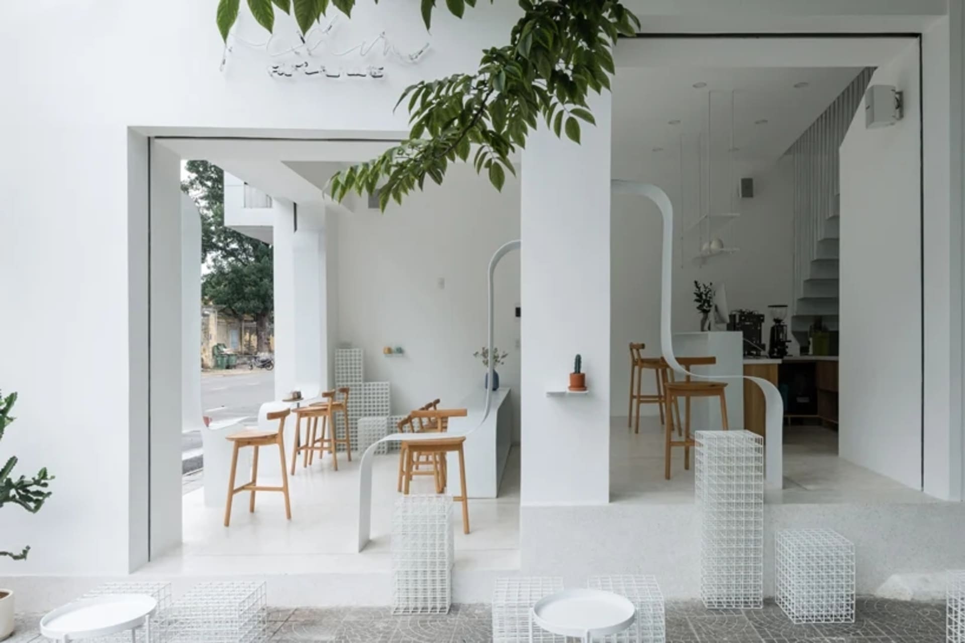 A minimalist cafe interior with white furniture and modern design elements.