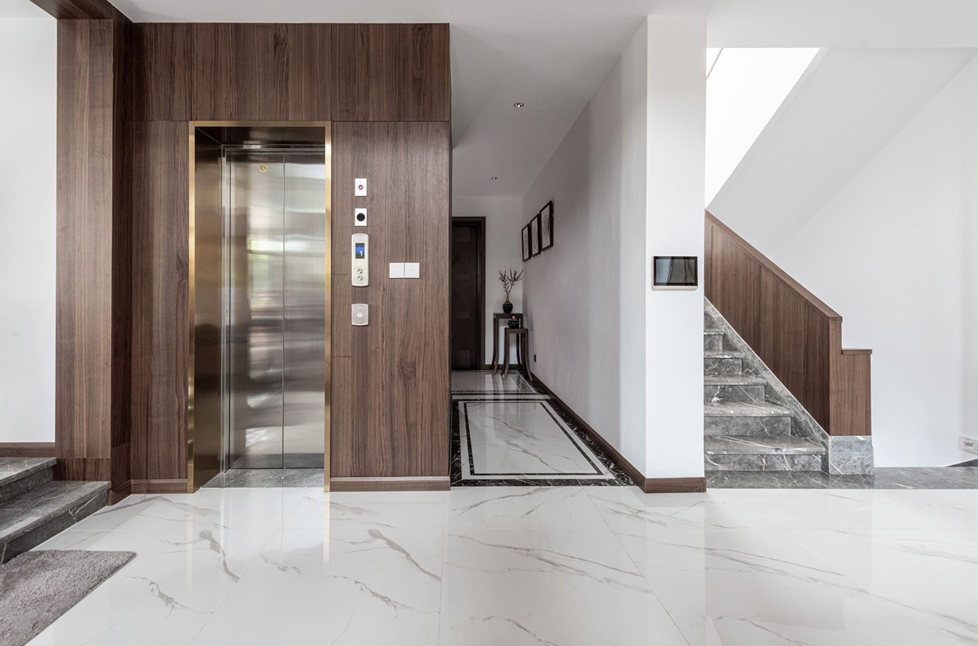 A modern lobby featuring marble flooring and interior design elements.