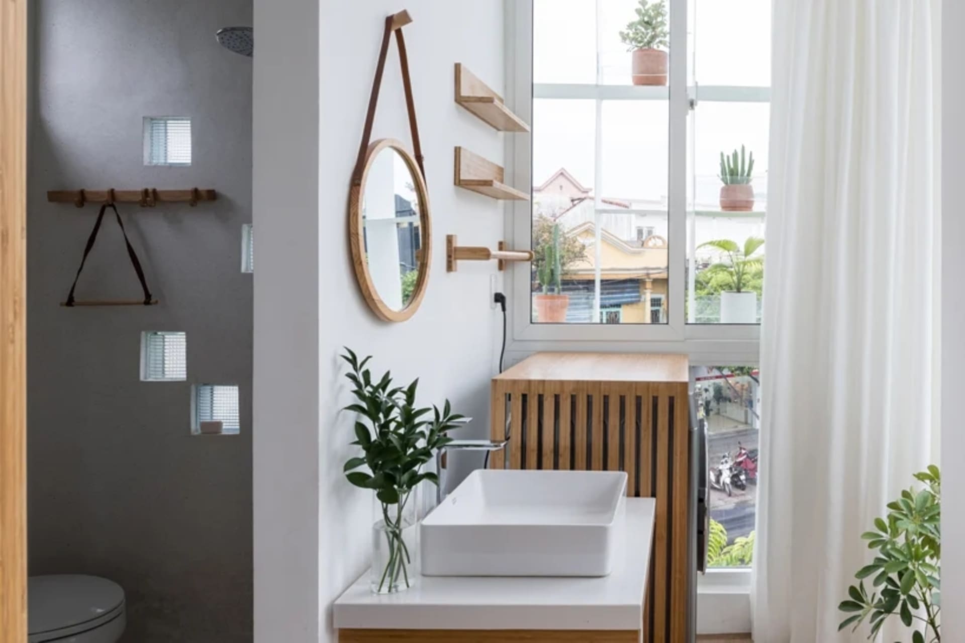 Modern bathroom featuring a white vessel sink, wooden shelves, and white shelves with glass block window