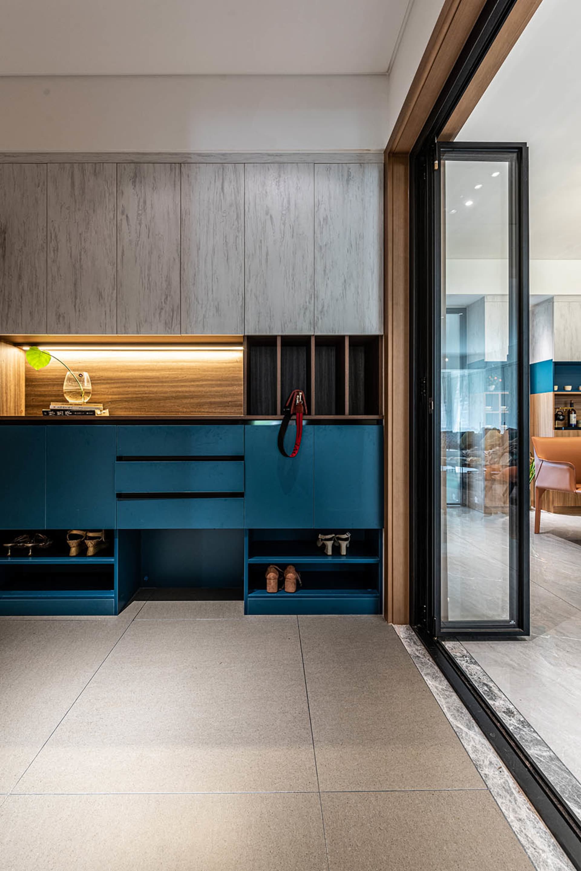 Modern blue entry way with contemporary cabinets and storage solutions.