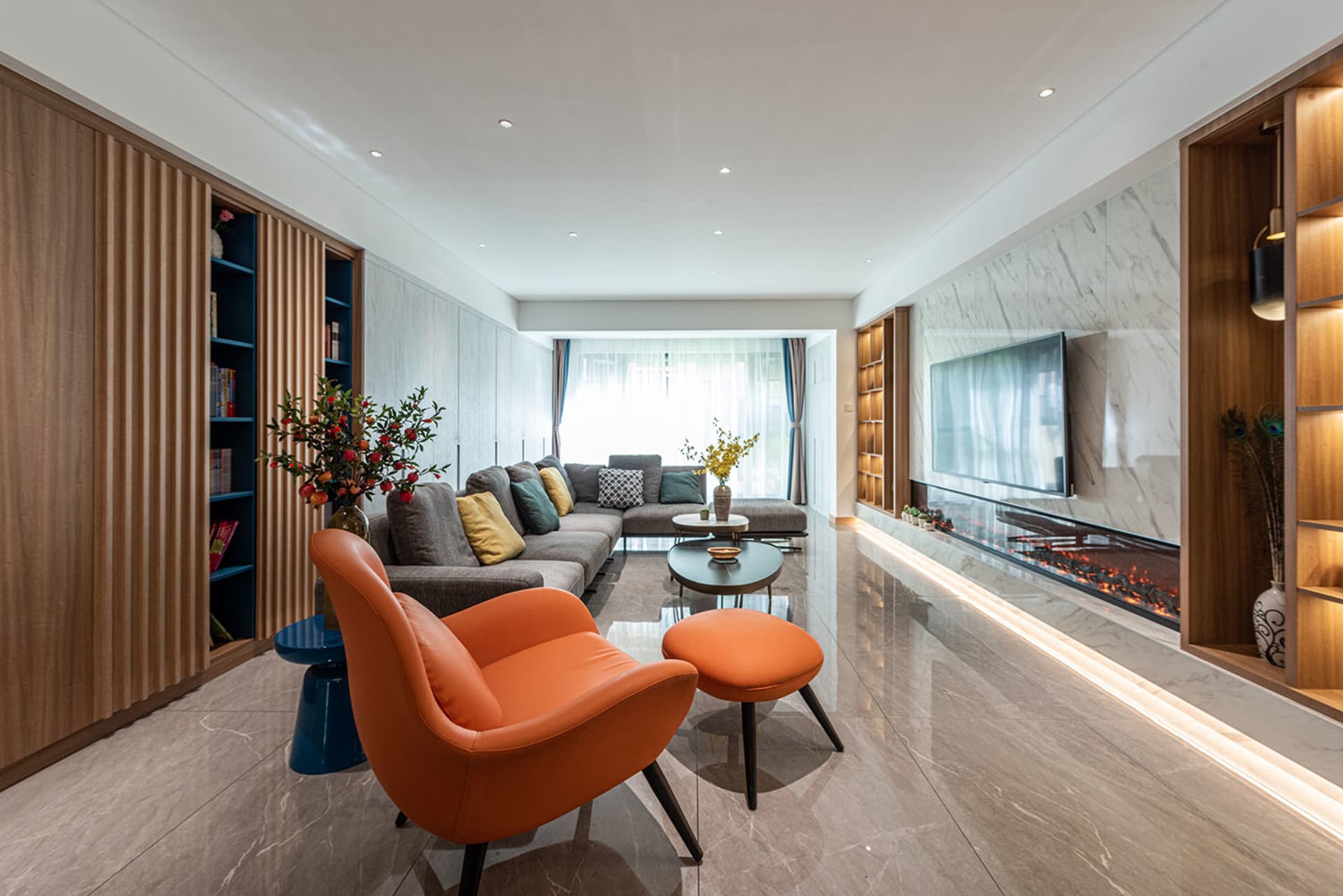 A modern living room featuring marble and concrete materials, mixed with wooden furniture and plants.