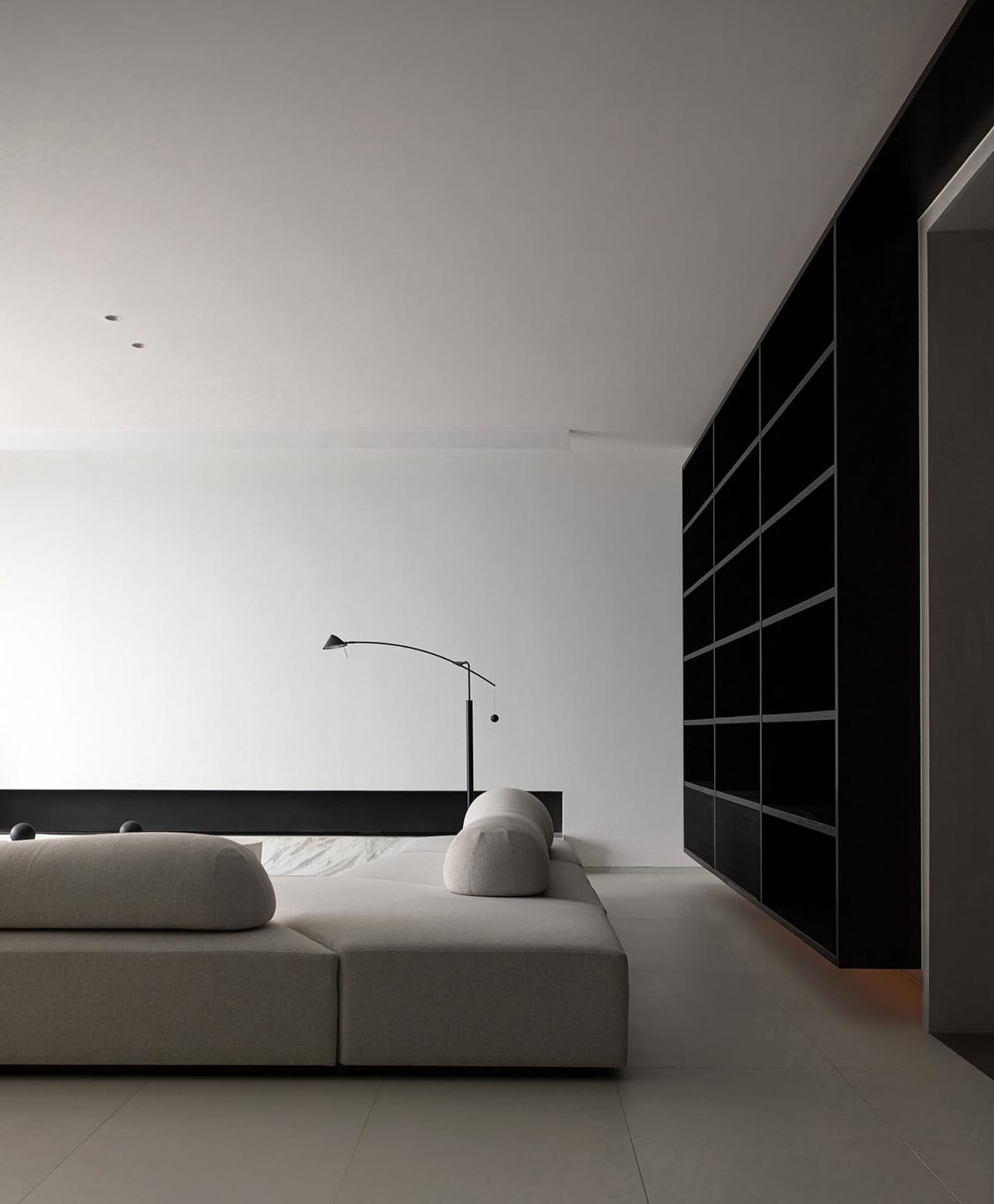 Modern living room with minimalist design, white walls, and a upholstered sofa.