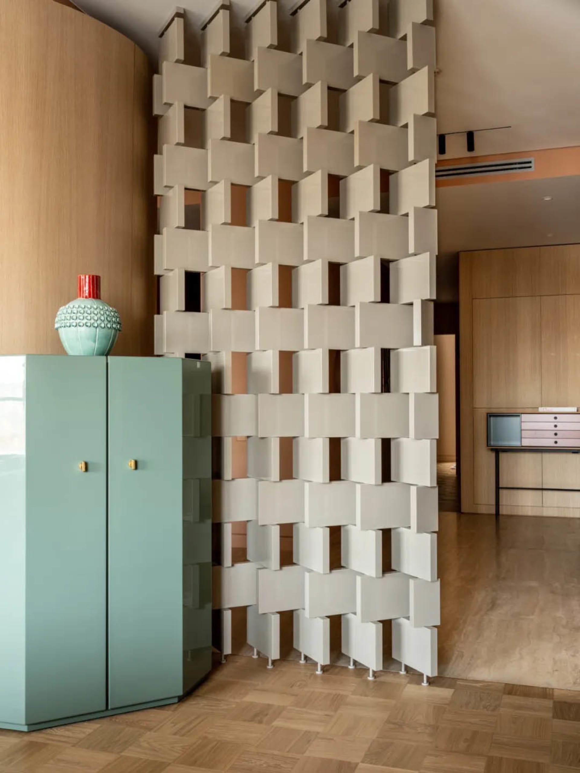 Living room featuring metallic cube wall and mint green cabinet