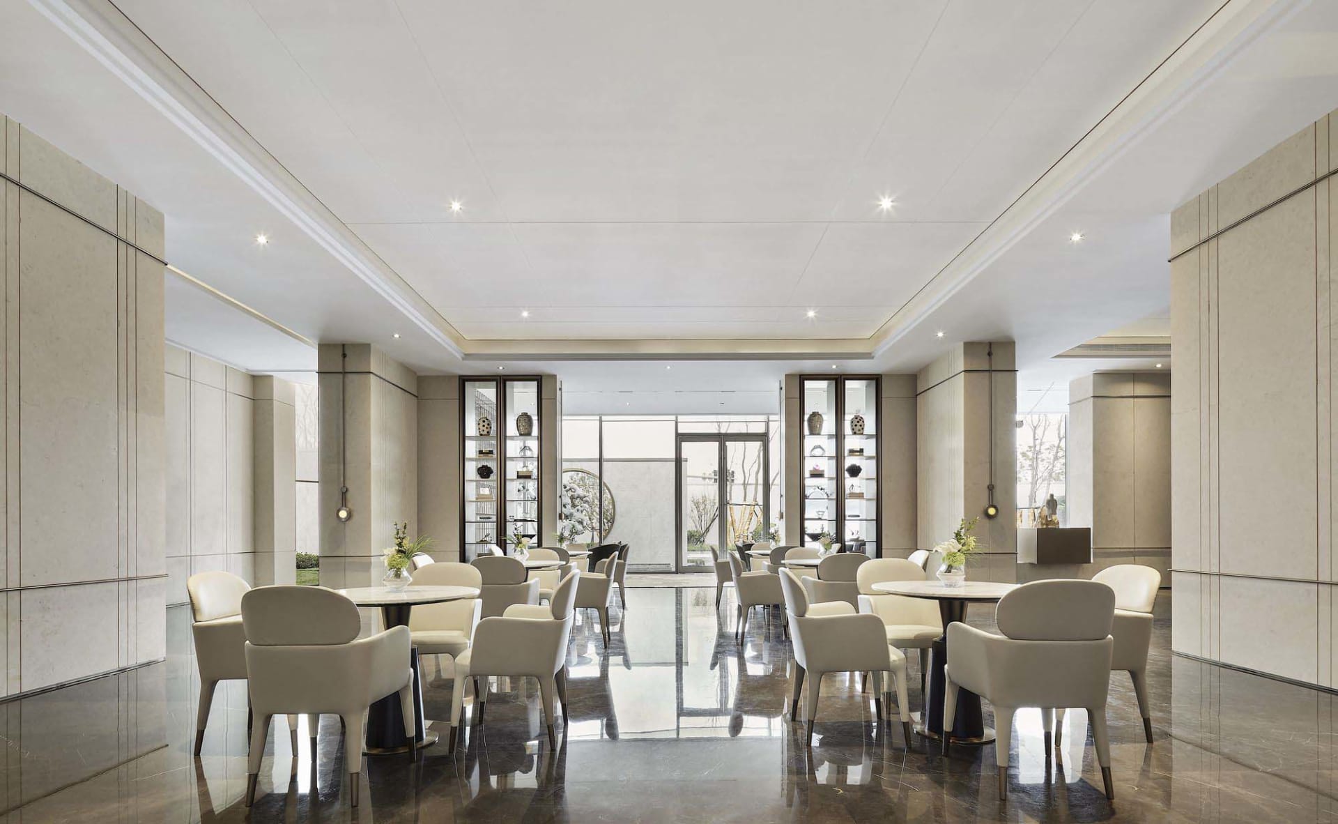 Modern hotel lobby with marble countertops, leather chairs, and glass displays.