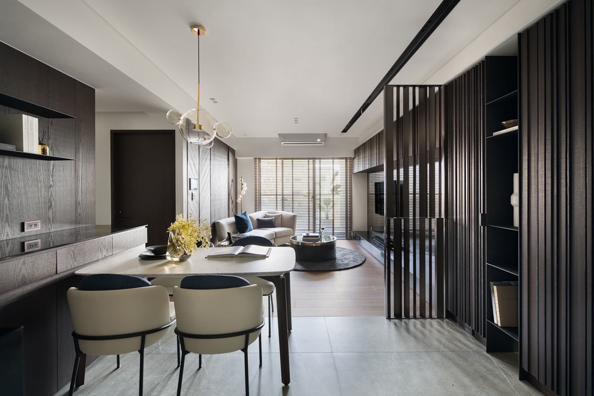 Modern living room with wooden furniture, glass coffee table, and metal accents.