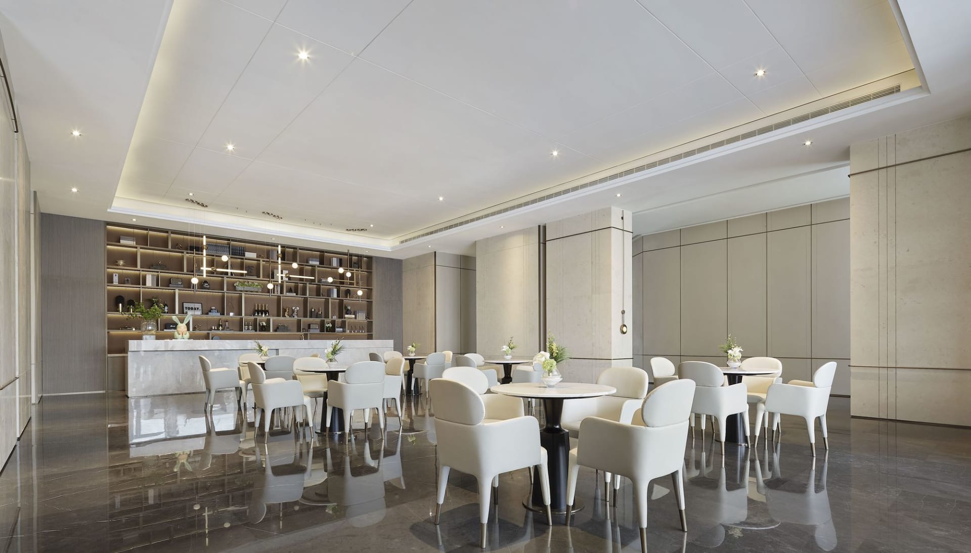 A modern restaurant interior featuring elegant white marble finishes and sleek white furniture.