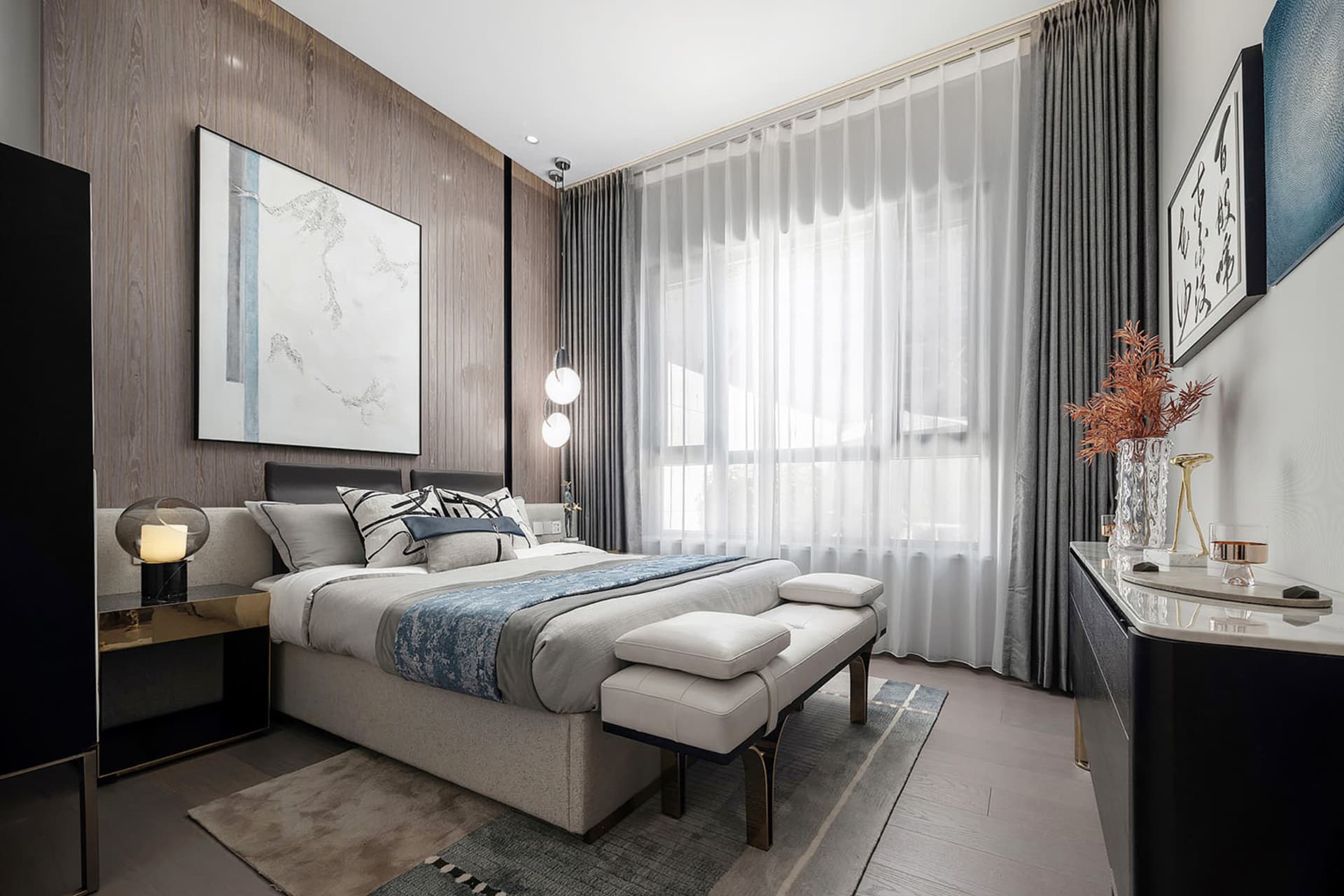 Contemporary bedroom with minimalist furniture, fabric bedding, and modern art.