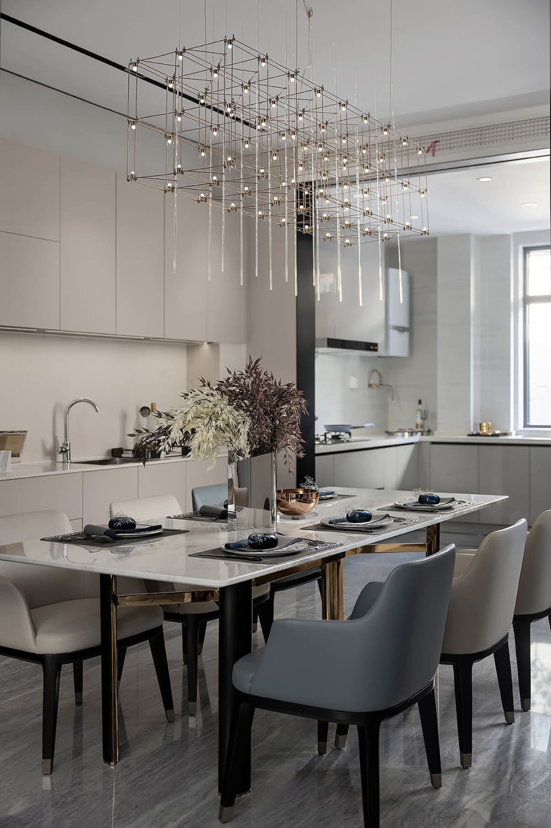 Modern dining area with marble table, glass chandelier, and metal chairs