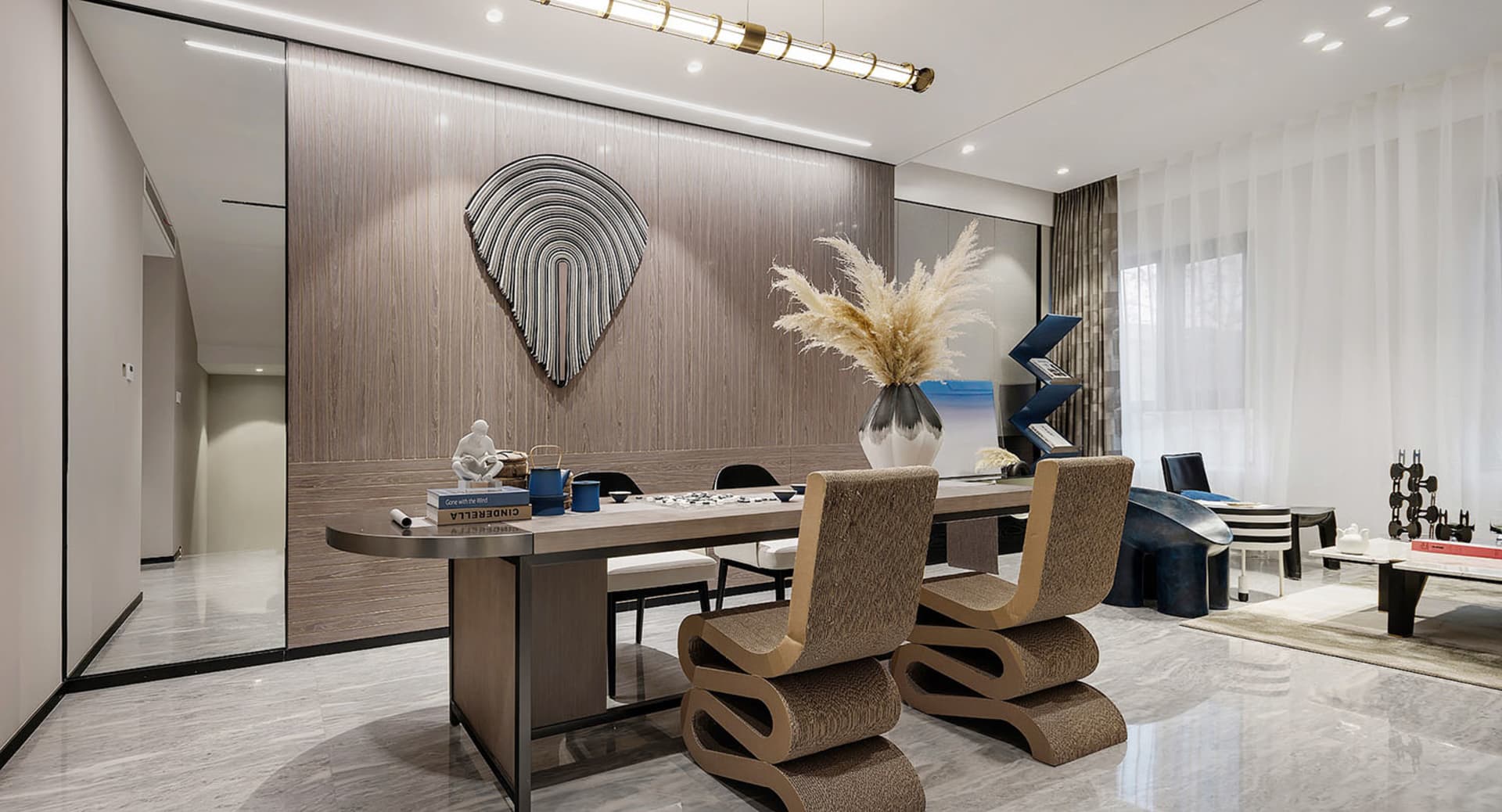 Modern living and dining room with wooden walls, glass surfaces, and textile furniture.