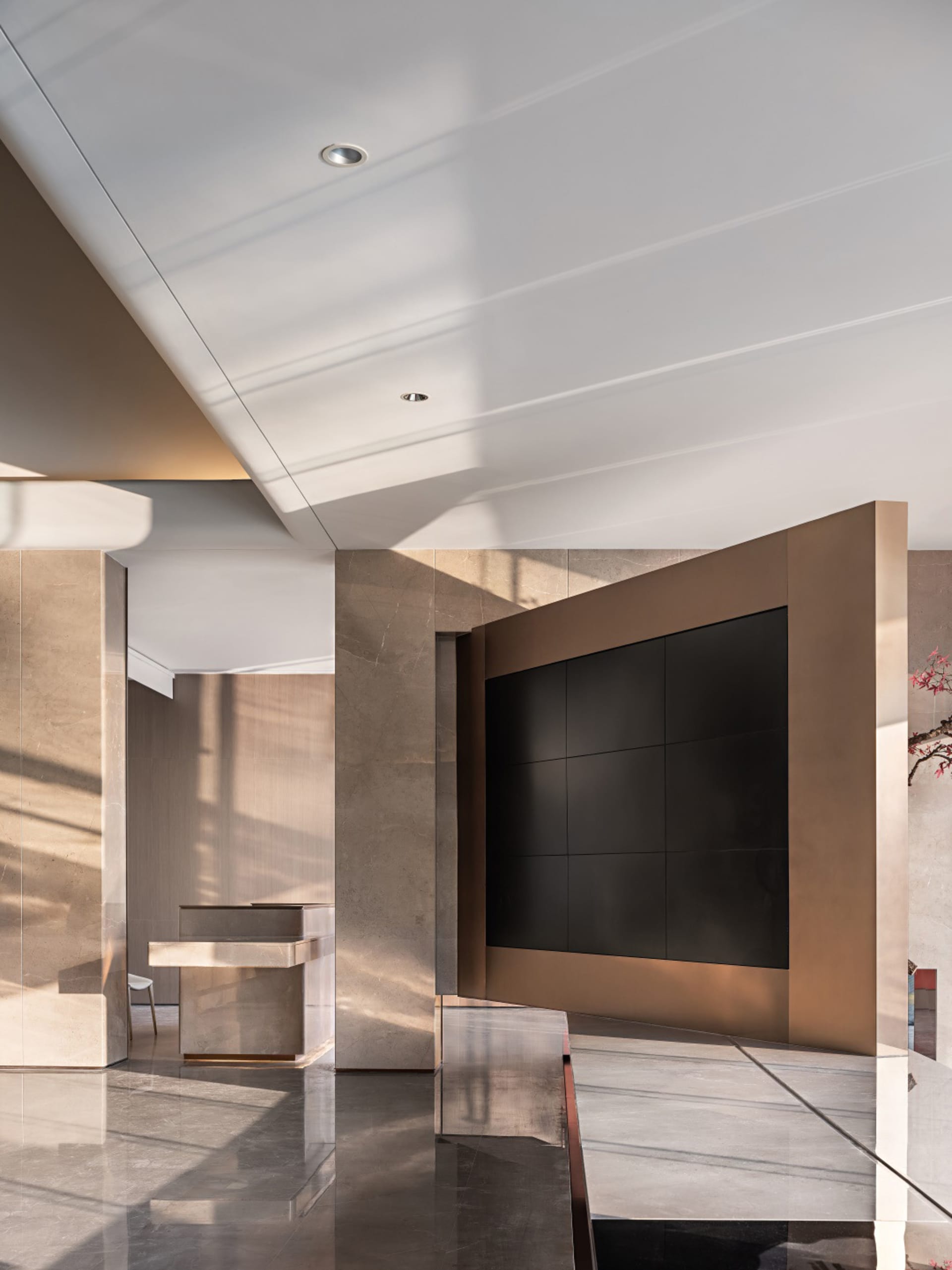 Modern lobby interior with metallic accent wall and reception desk.