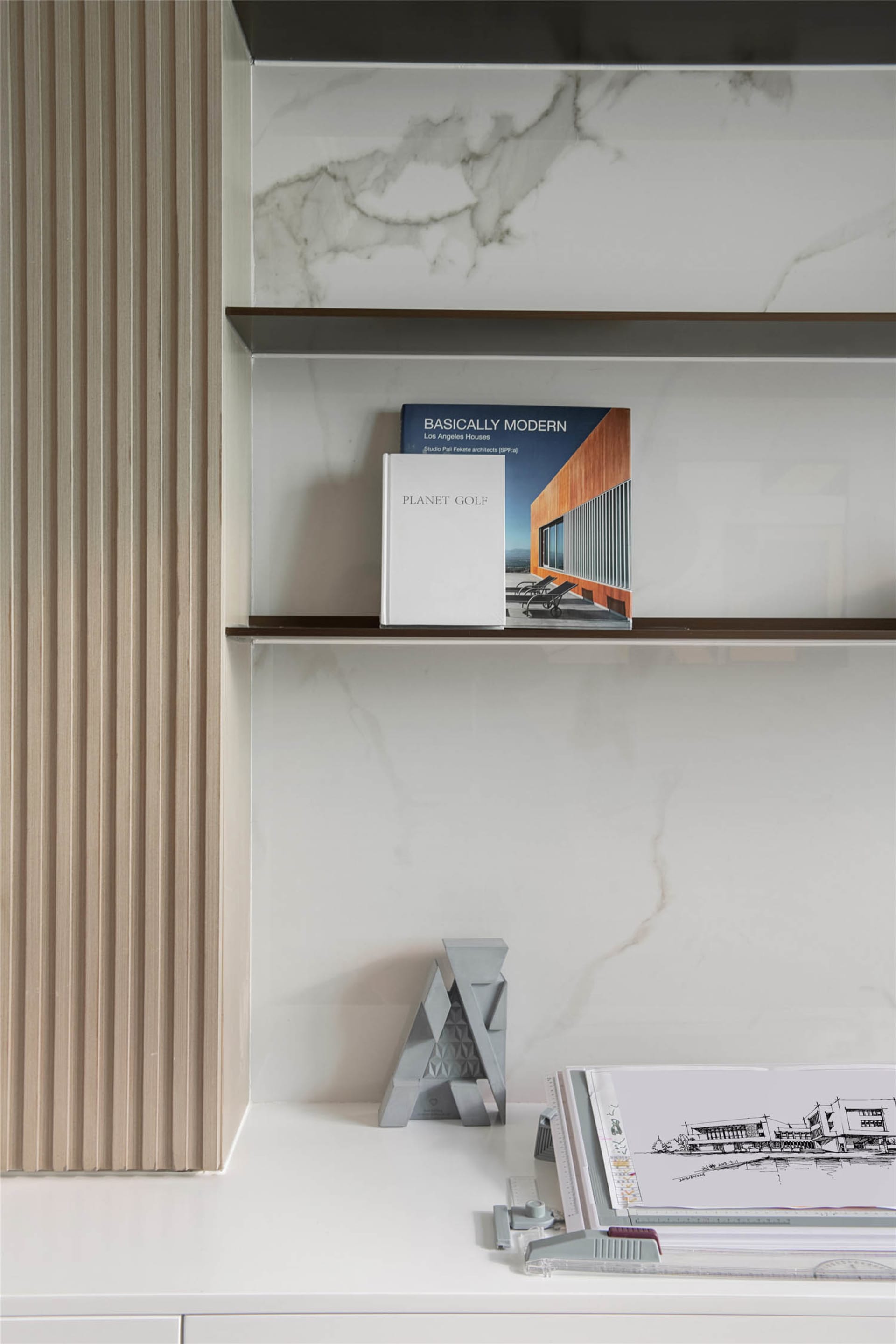Modern marble shelves with books and architectural models.