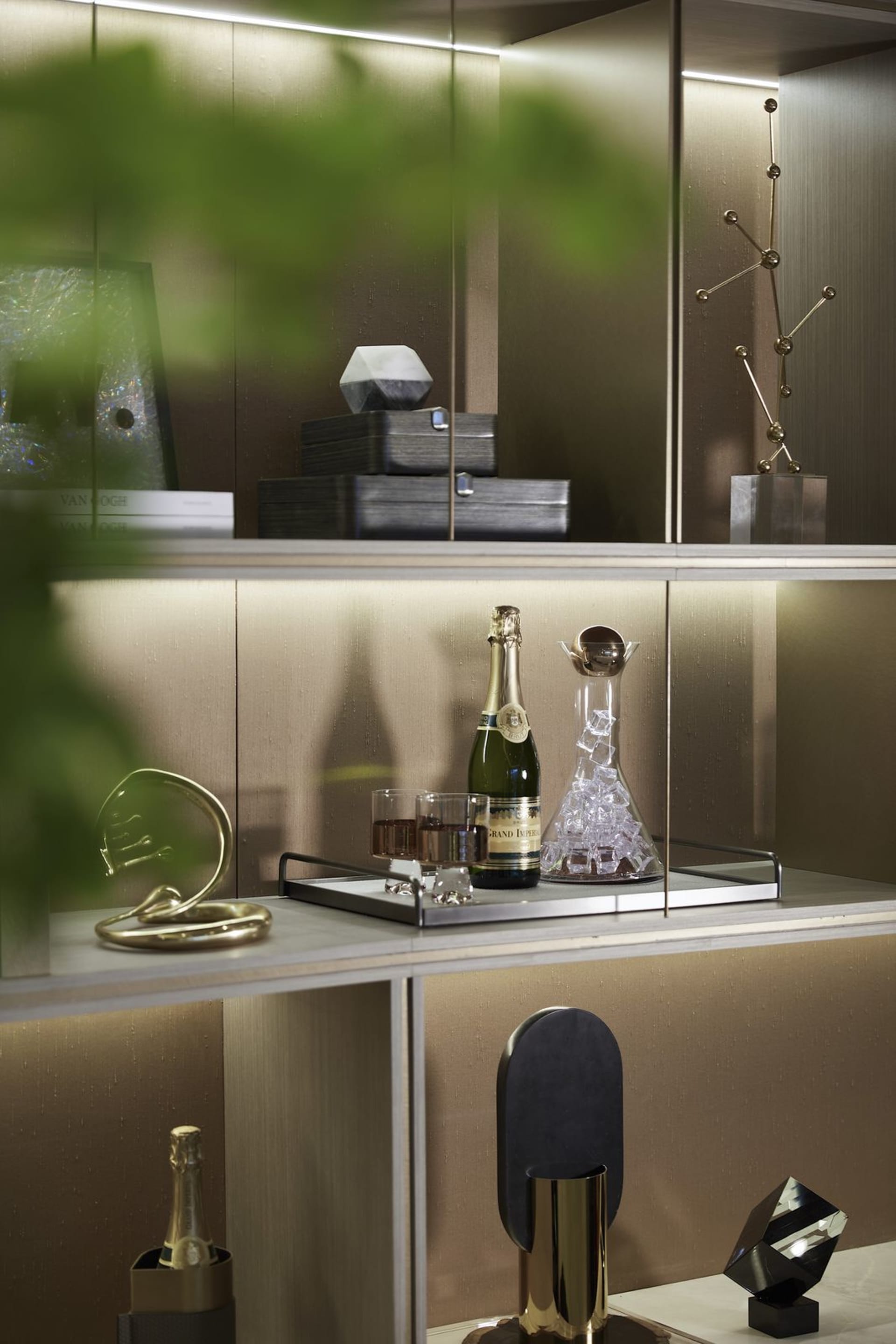 A stylish modern bar display featuring gold accessories and a bottle of champagne.