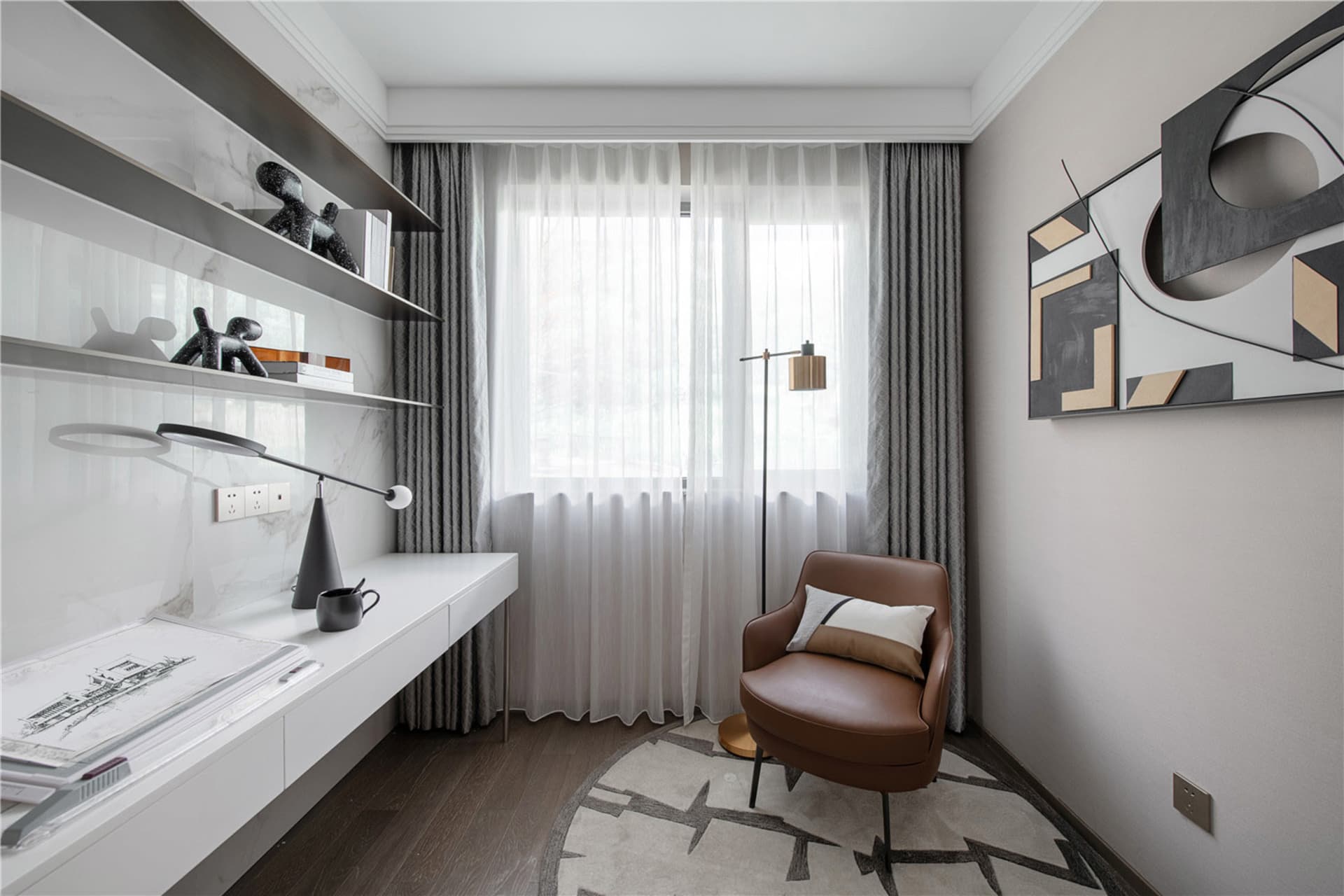A modern home office with minimalist furniture and a comfortable armchair.