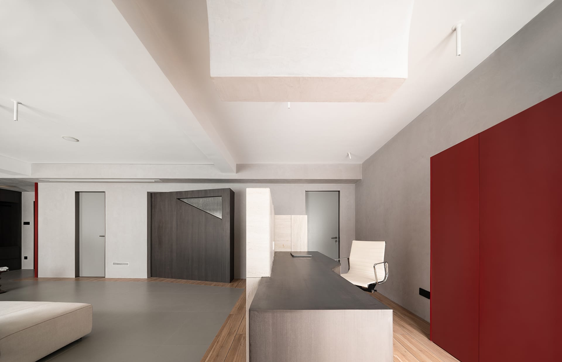 A modern industrial office space featuring exposed concrete floors and walls.
