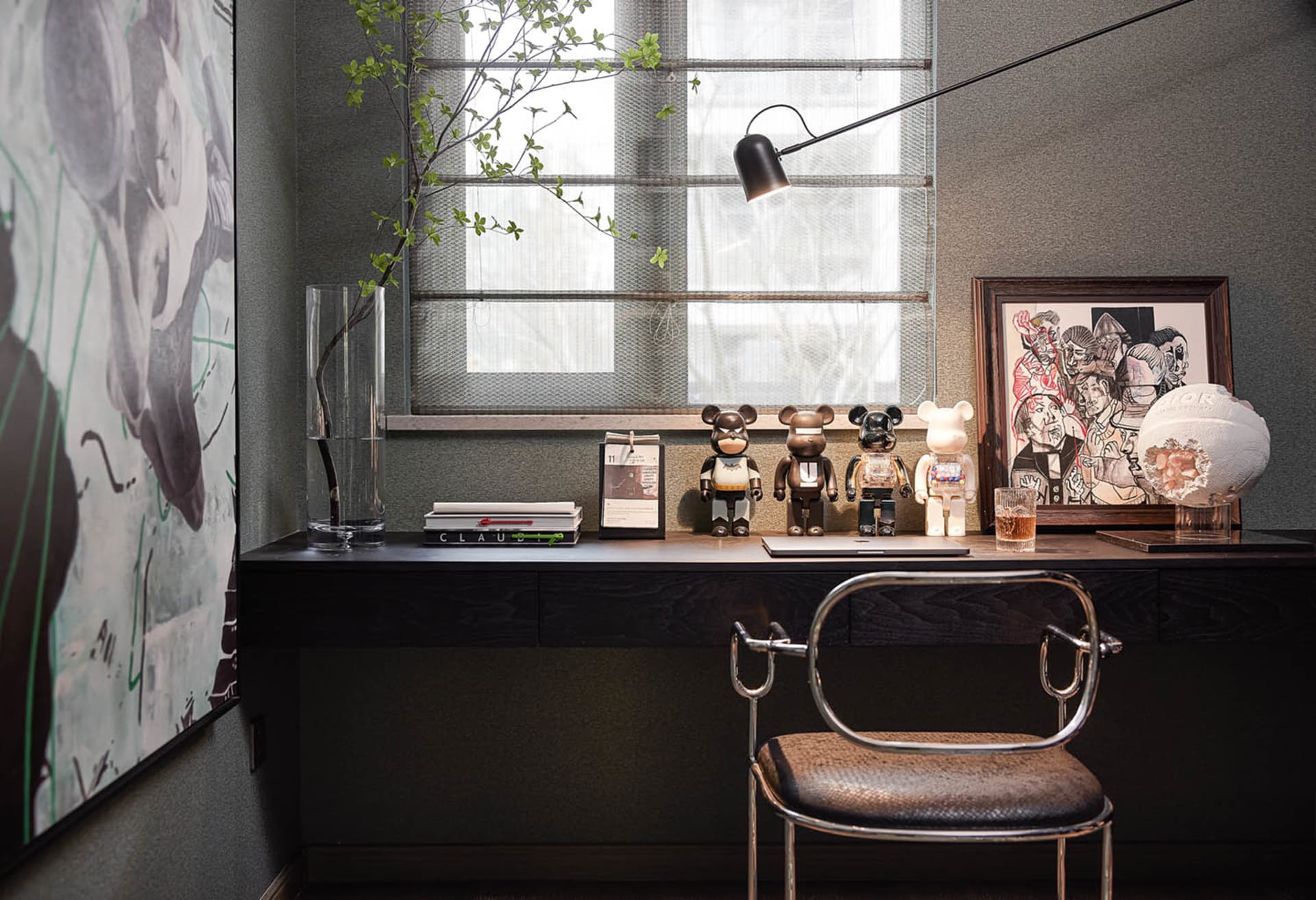 A modern home office with a desk, chair, and various decorative items.