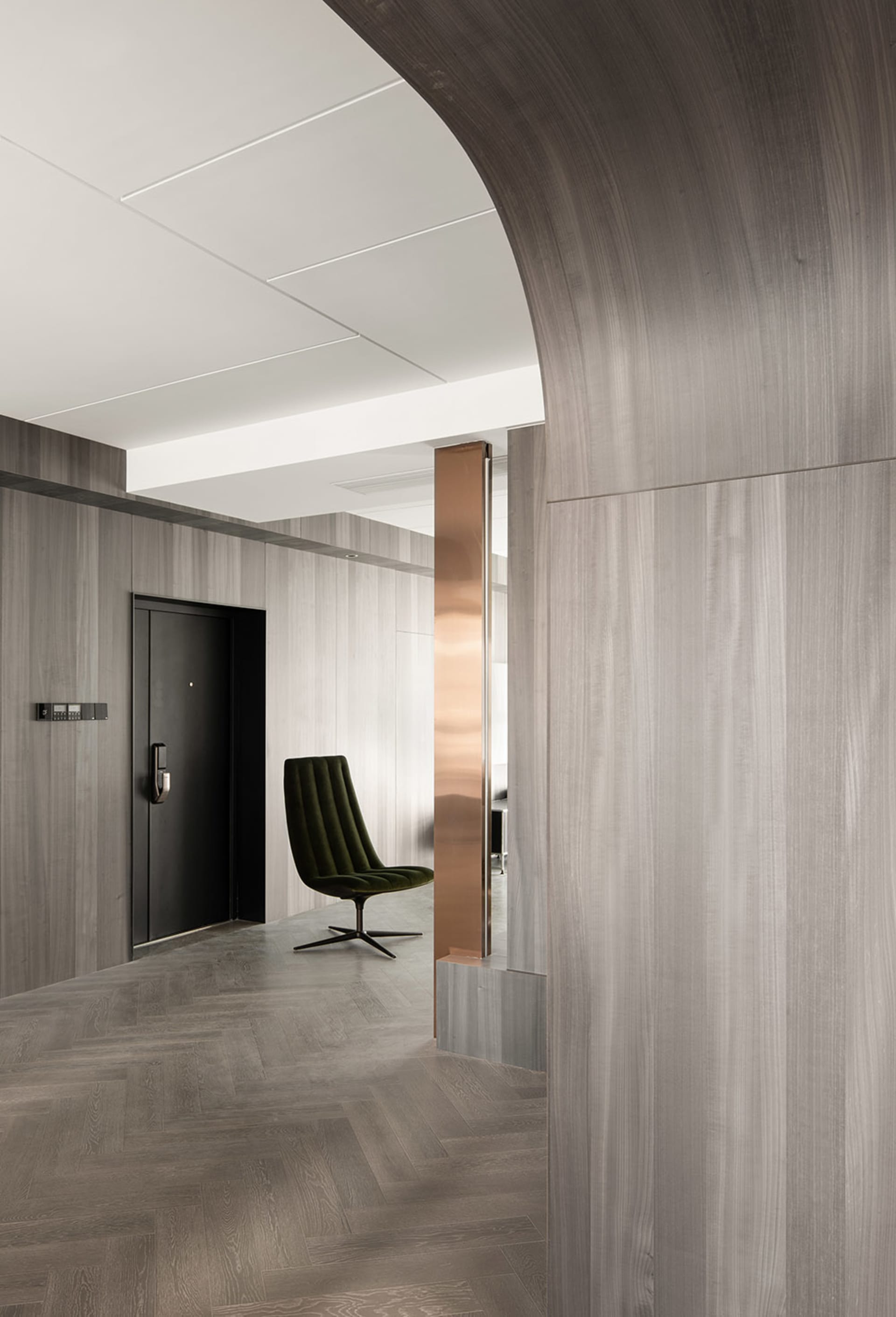 A modern home office with dark wood walls and a sleek, green swivel chair.