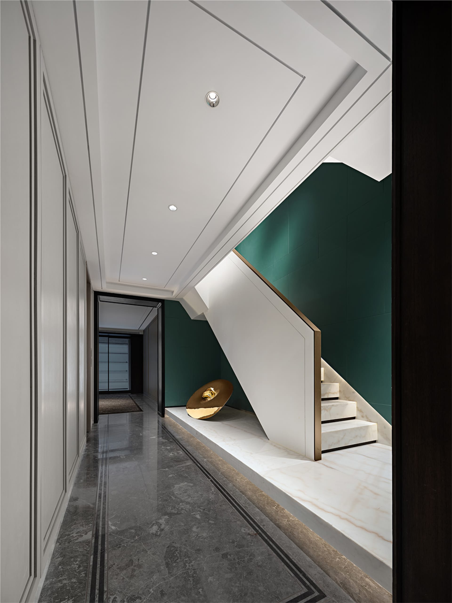 Modern, minimalist residential interior design featuring a marble staircase with a green accent wall and a minimalist art ins