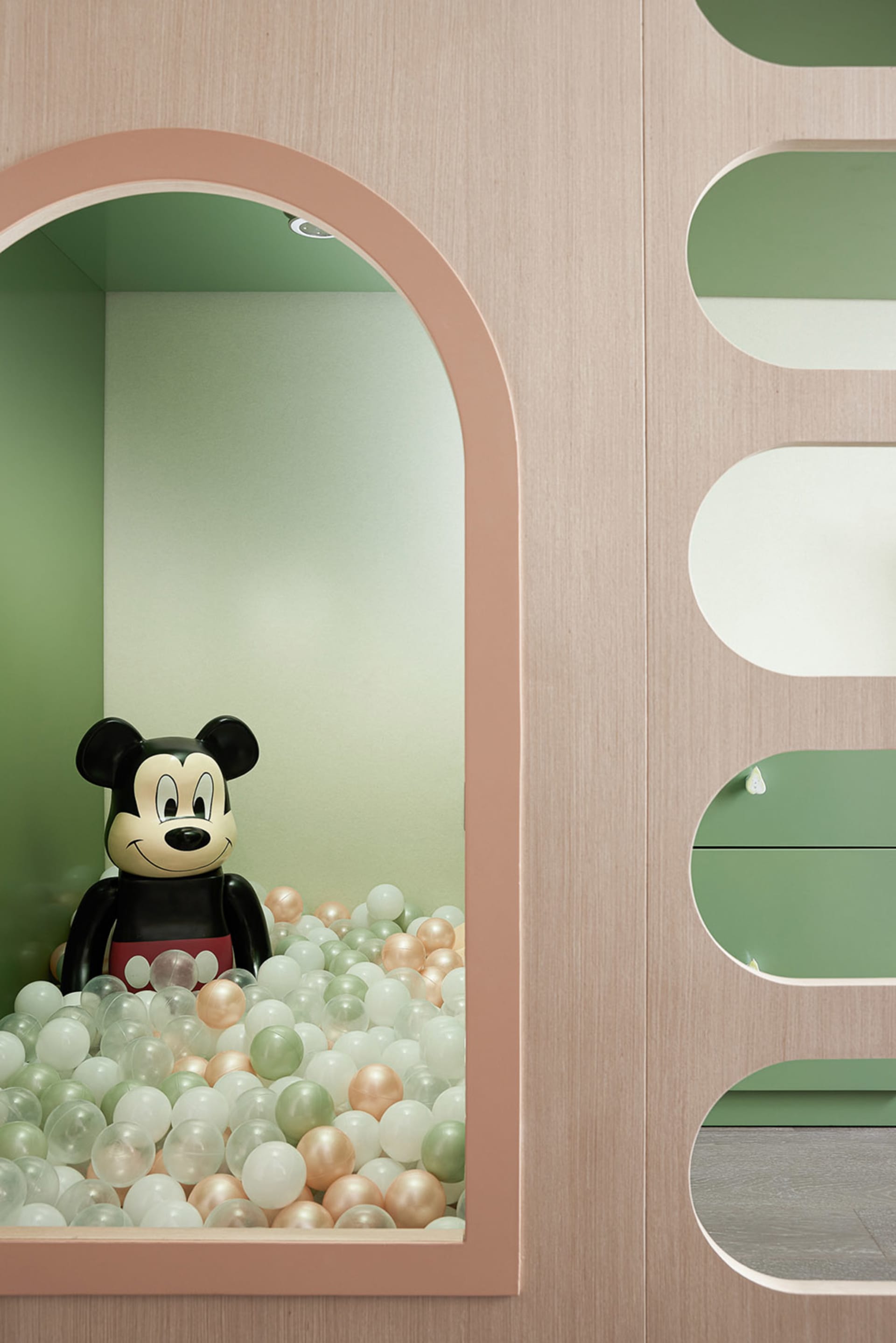 A modern playroom featuring a ball pit filled with colorful balls and plastic building blocks, designed for children's entert