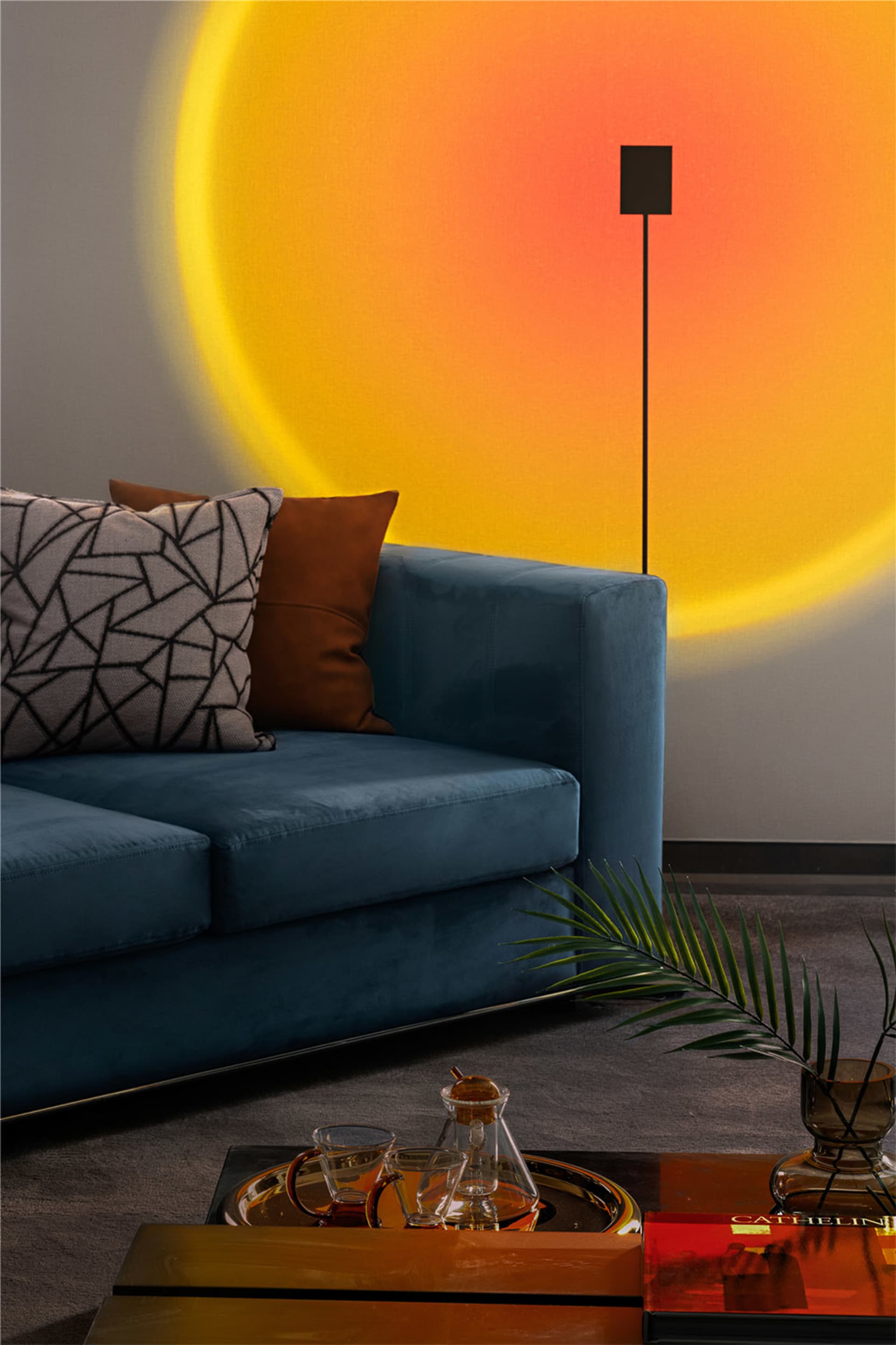 Blue sofa with geometric and brown pillows, illuminated by a sunburst shadow.