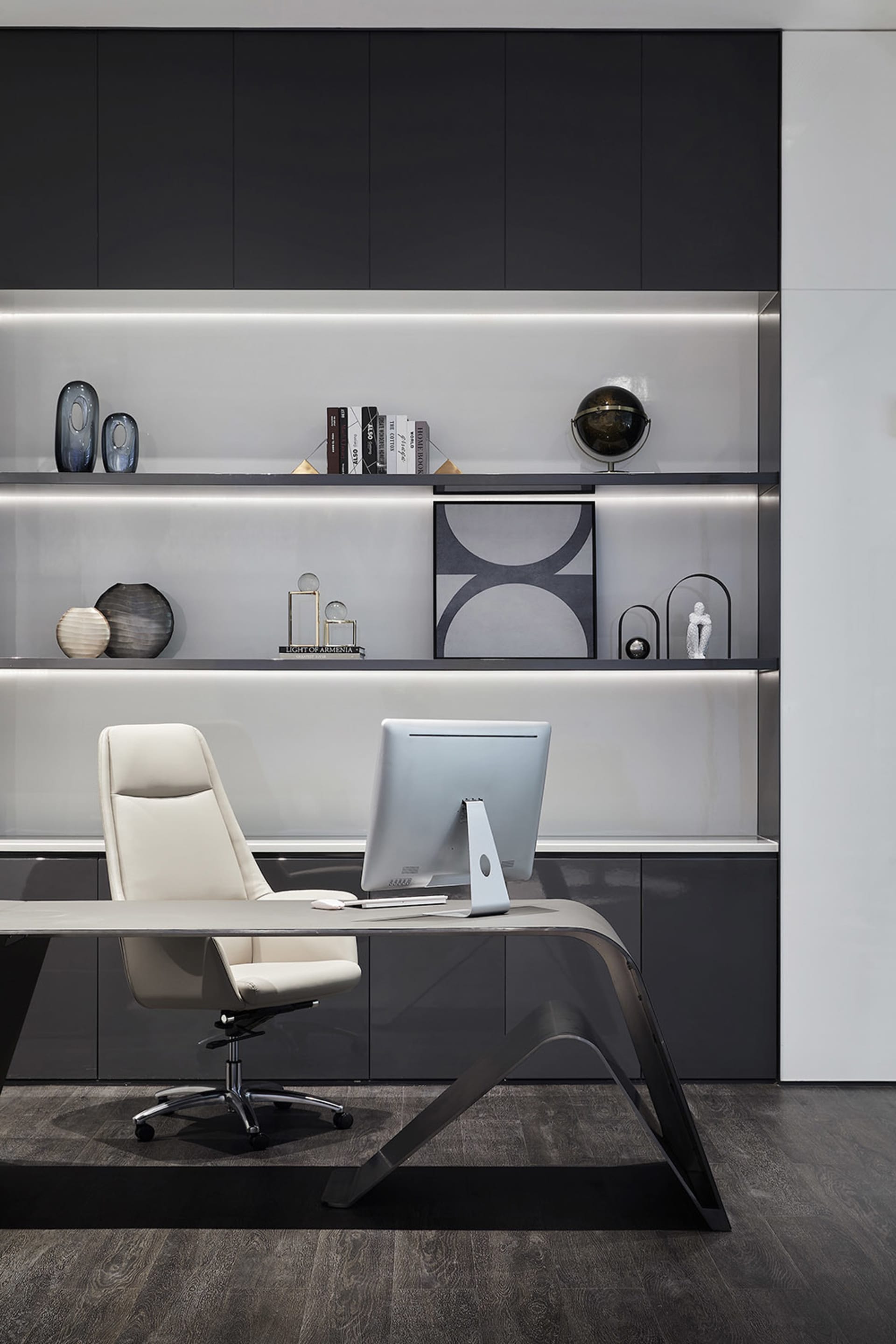 A modern office space featuring a sleek desk, white office chair, and a minimalist black and white color scheme with a glass