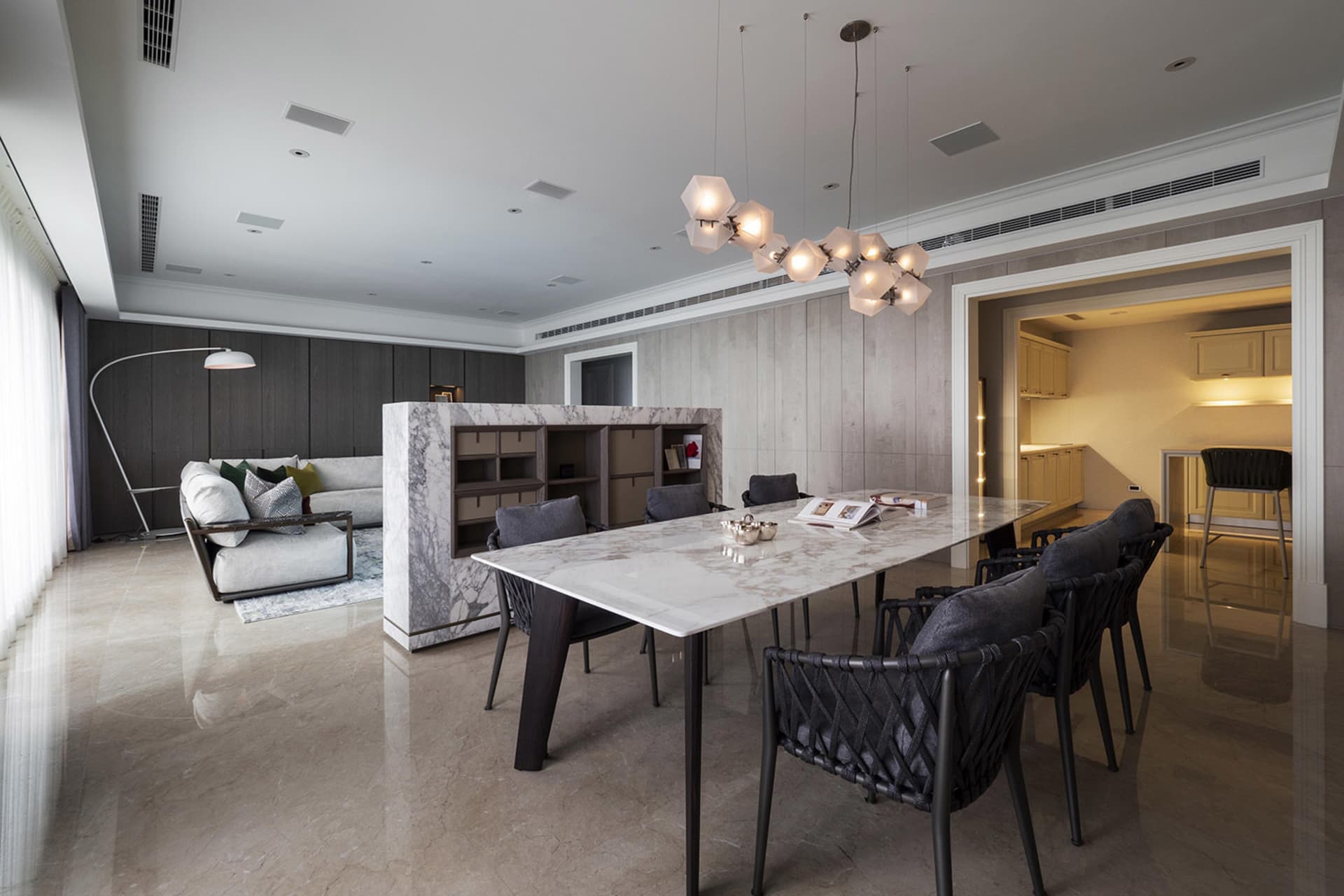 A stylish modern dining room featuring a marble table and contemporary furniture.
