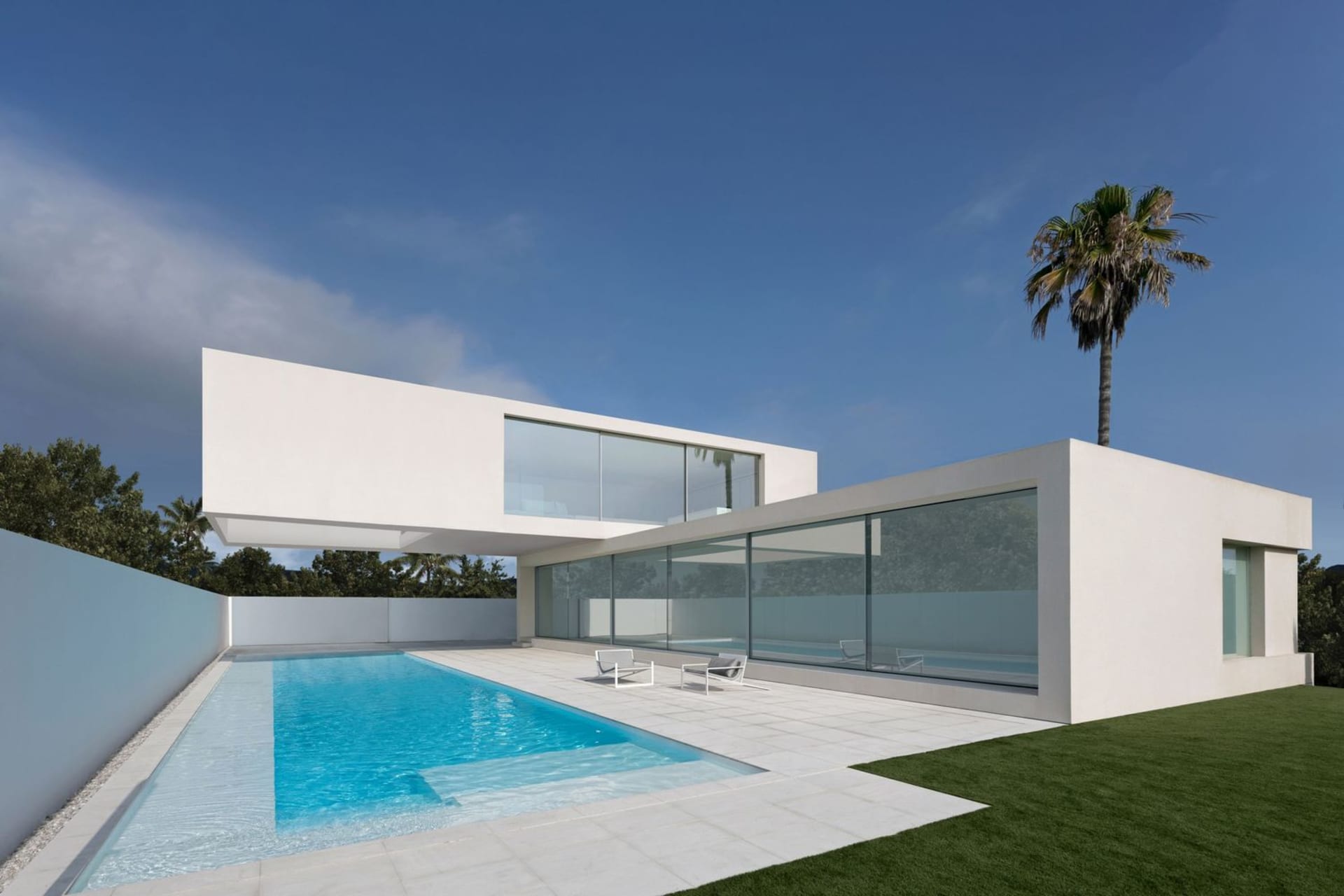 A modern residential house with a glass facade and a swimming pool.