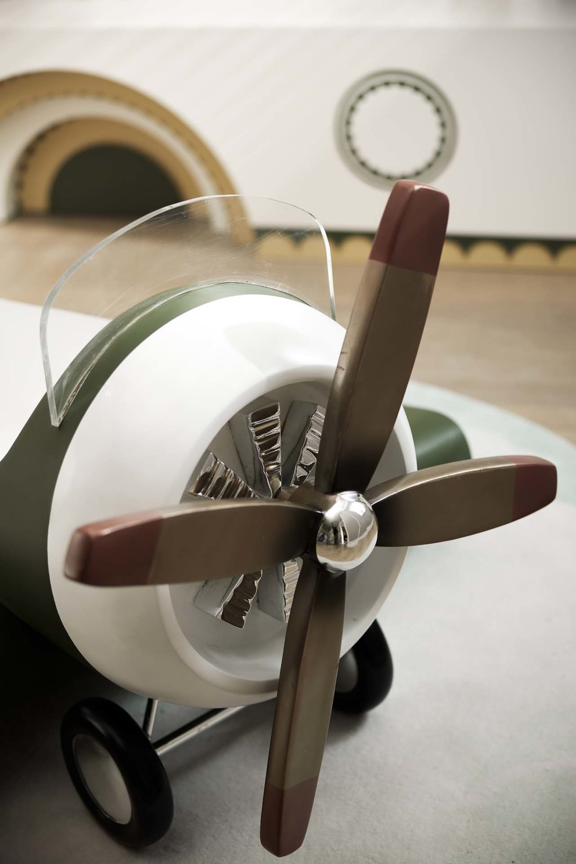 An industrial-style toy airplane with a metal propeller.