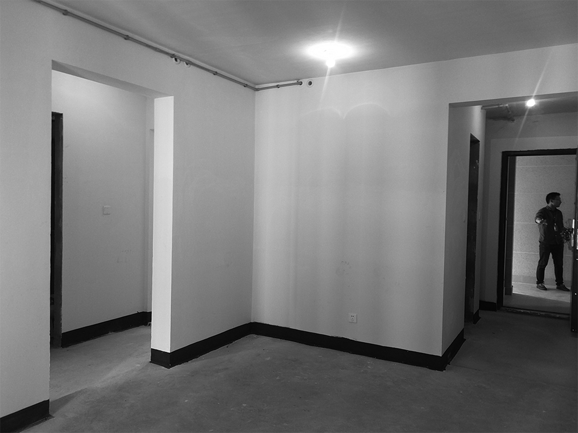 A minimalist interior space featuring concrete walls and floors.