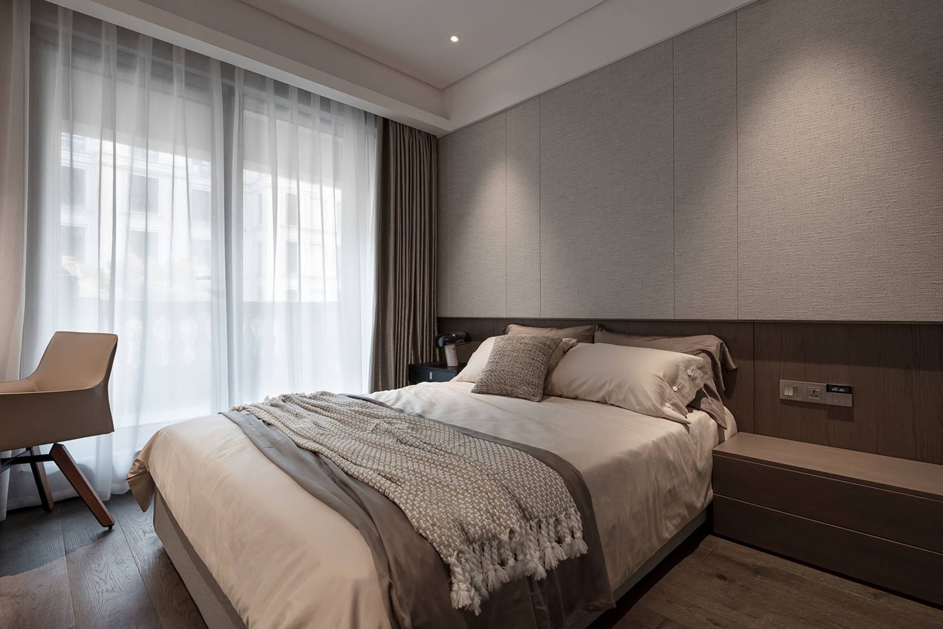 Modern bedroom with neutral-toned bedding and minimalist design.