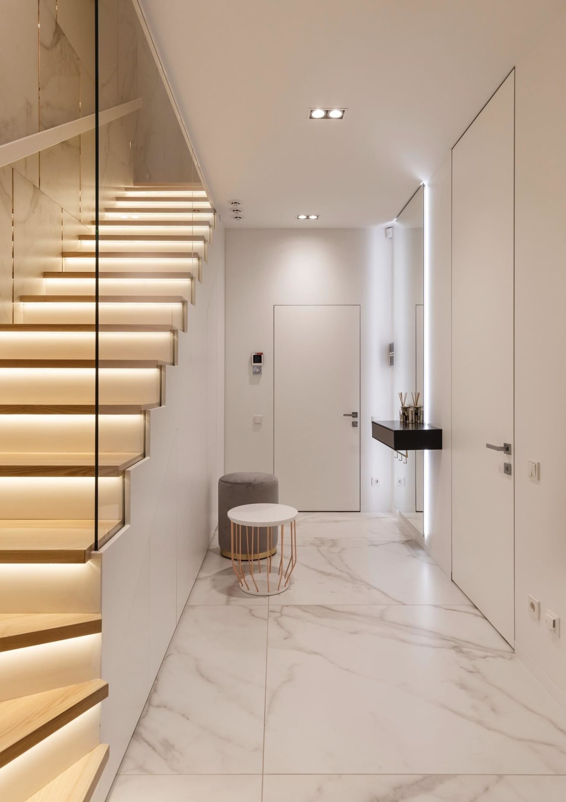 Modern entryway featuring marble flooring, minimalist design, and sleek, elegant lighting.