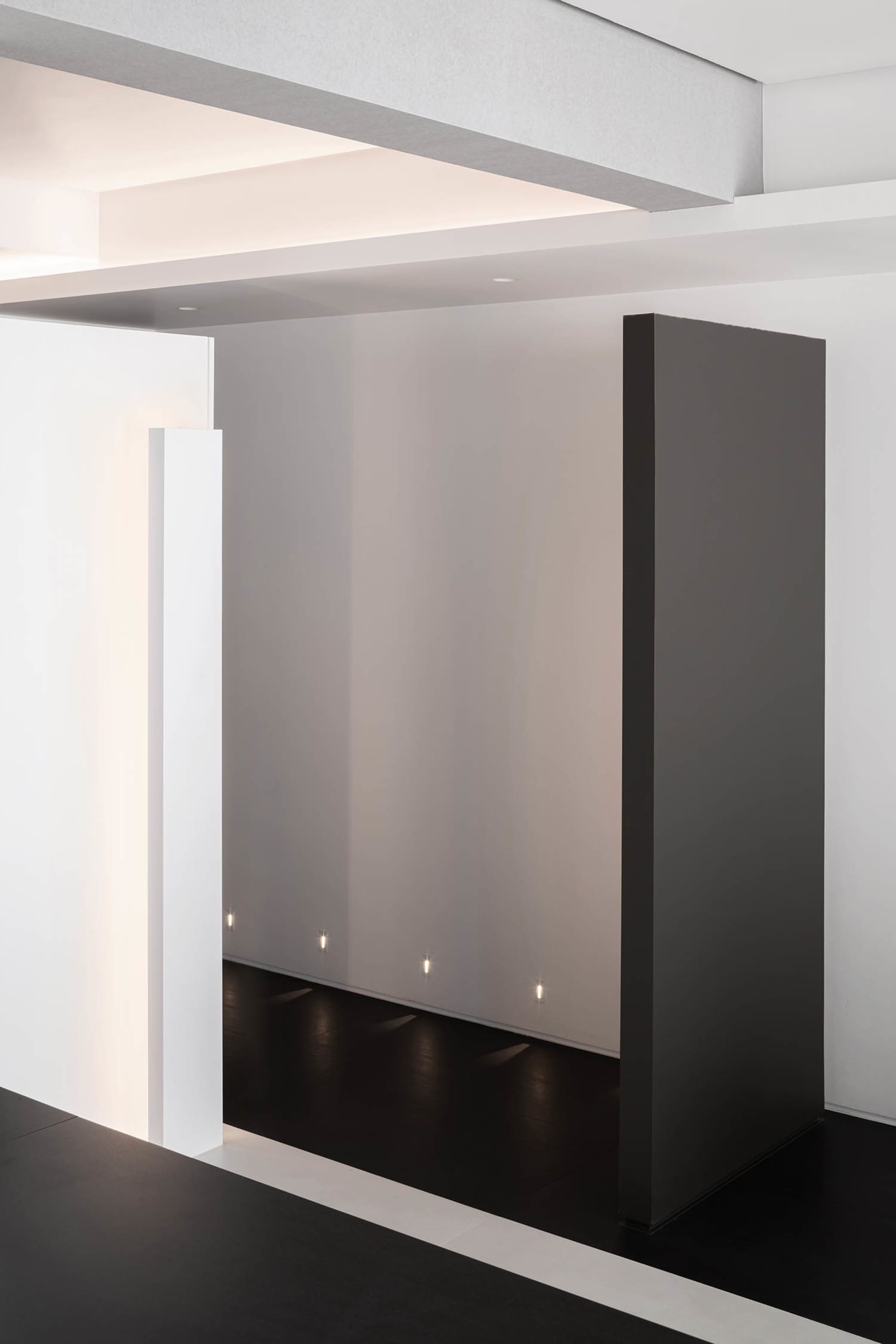 A minimalist office space featuring metallic surfaces and a clean, geometric design.