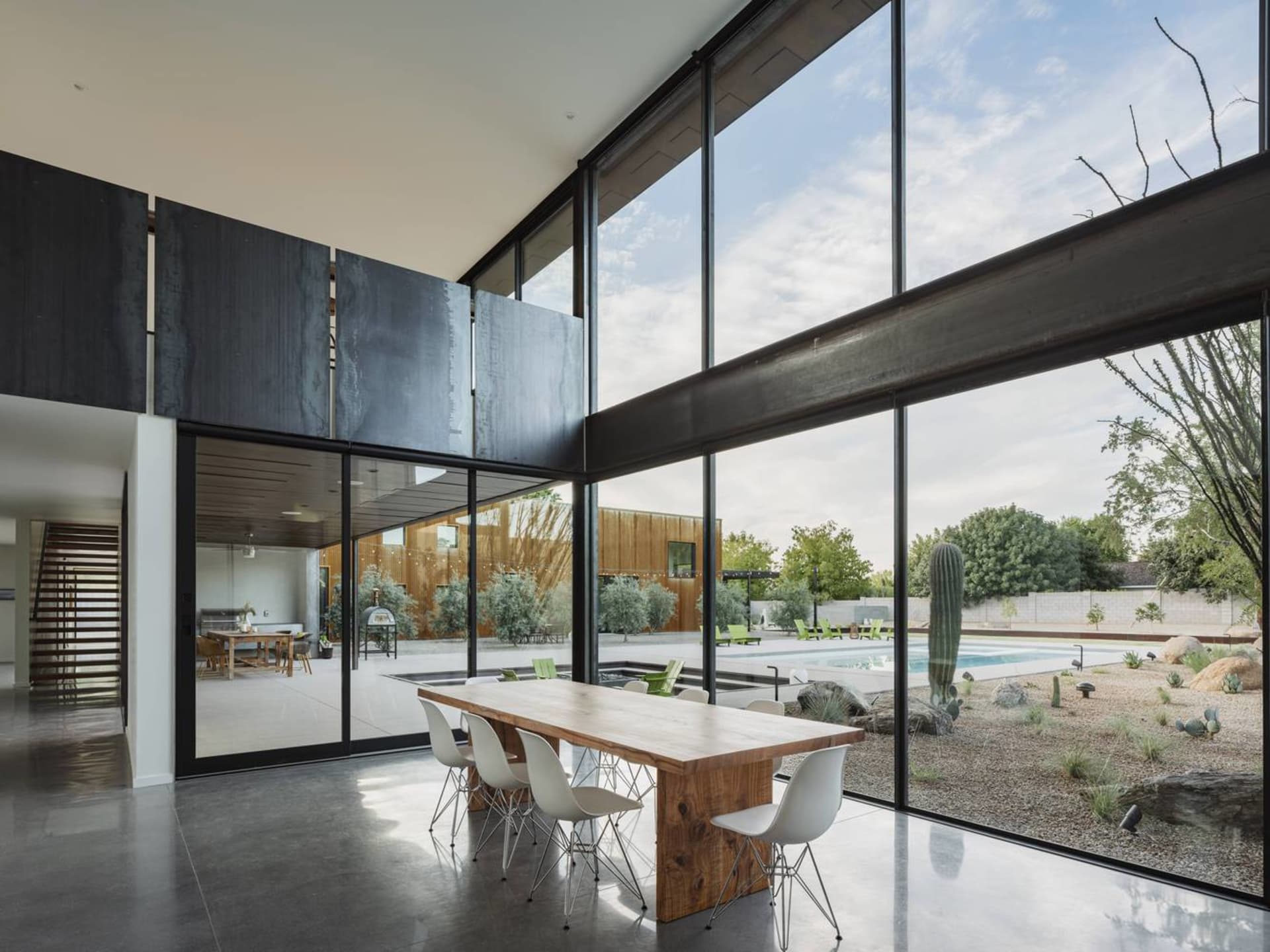 Modern minimalist dining room featuring concrete and large glass windows.