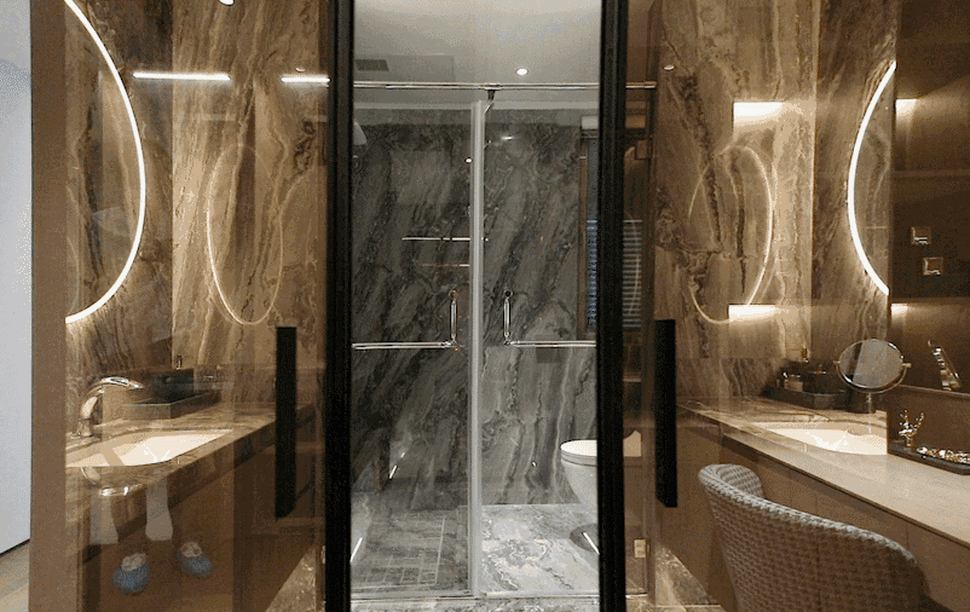 A modern bathroom featuring marble tiles, a walk-in shower, and a toilet.