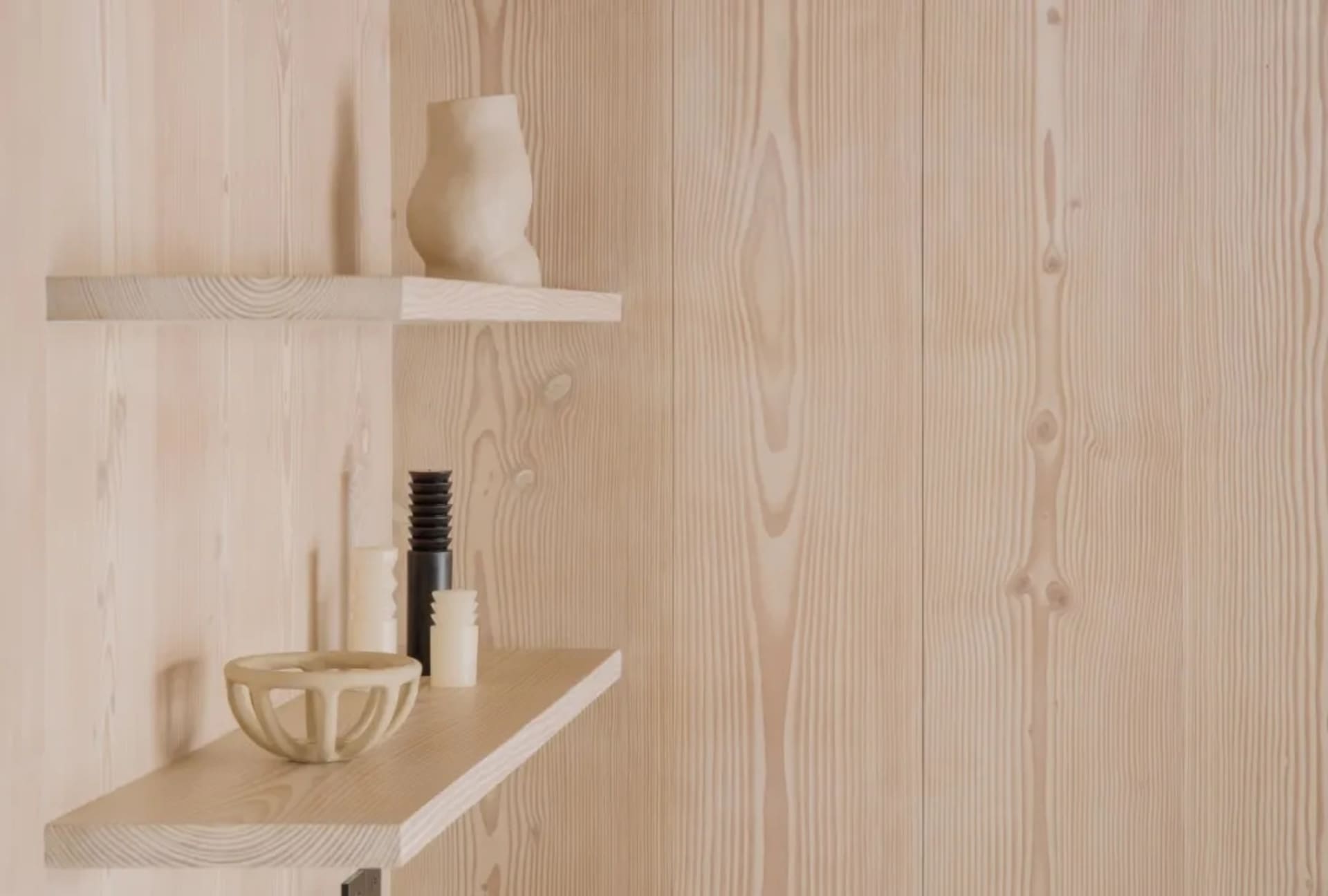 A minimalist wooden bookshelf with various decorative items.